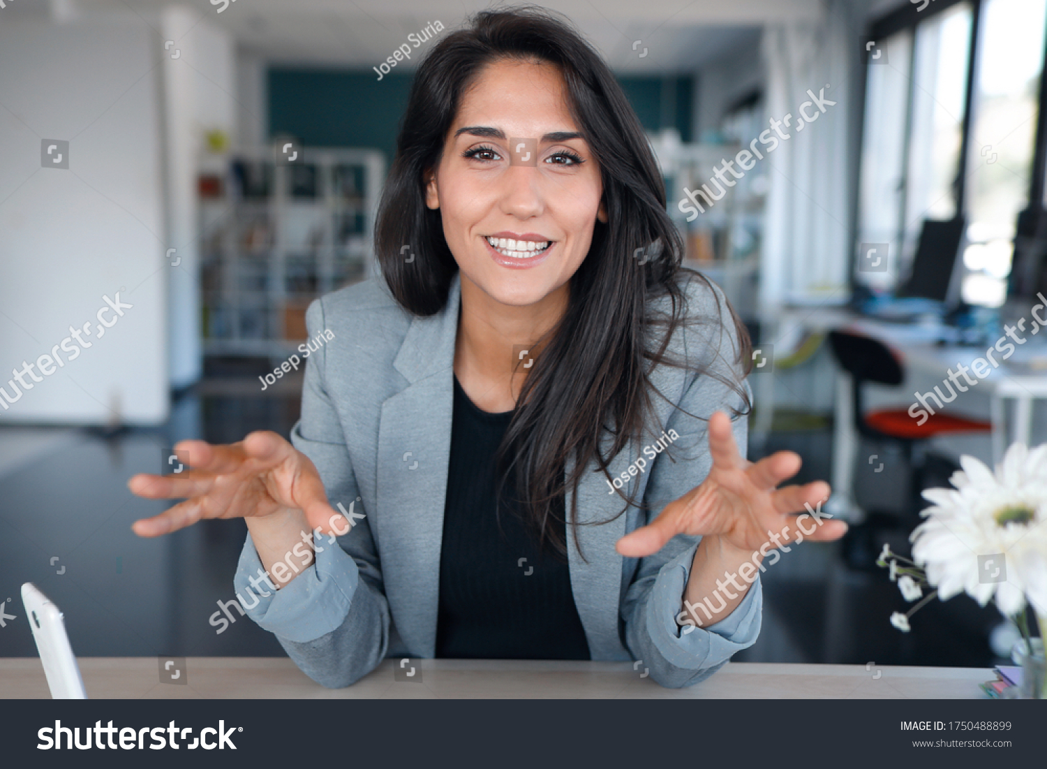 Shot of confident business woman looking and speaking through the webcam while making a video conference from the office. #1750488899