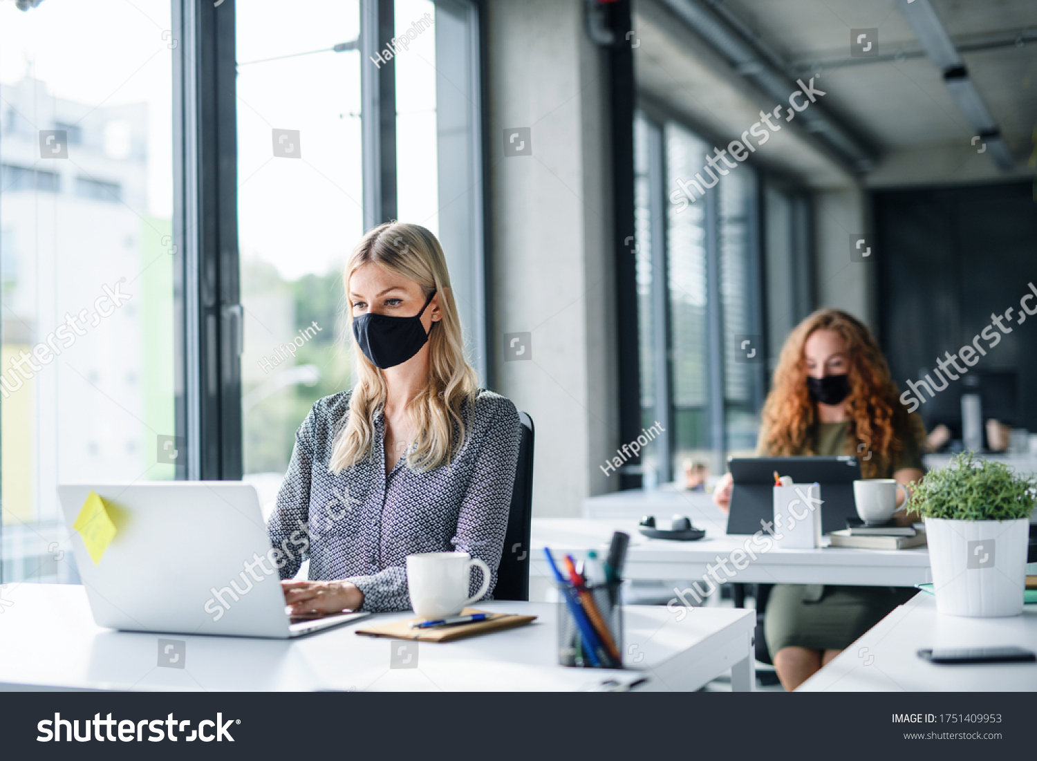 Young people with face masks back at work or school in office after lockdown. #1751409953