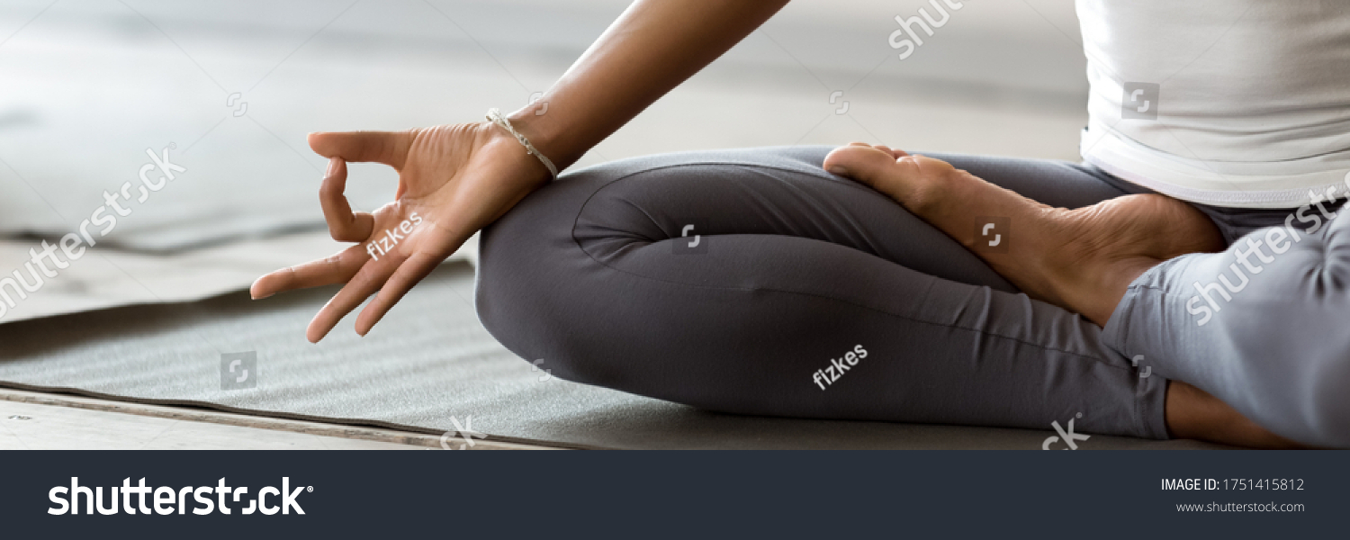 African woman wearing active wear do yoga practice meditating indoors, close up cropped photo lotus position. No stress, mindfulness, inner balance concept. Horizontal banner for website header design #1751415812