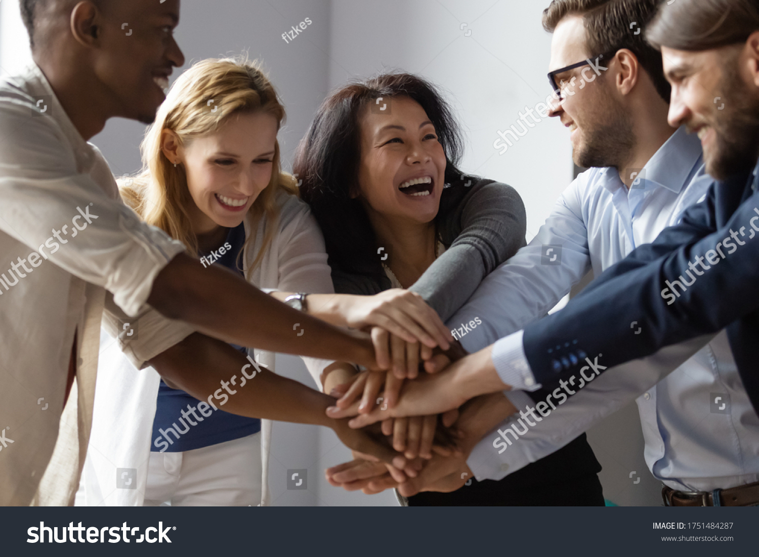Close up image overjoyed 5 multi ethnic business people stack touch arms palms together celebrating promotion reward, succeed common aim. Give high five symbol of unity, team building activity concept #1751484287