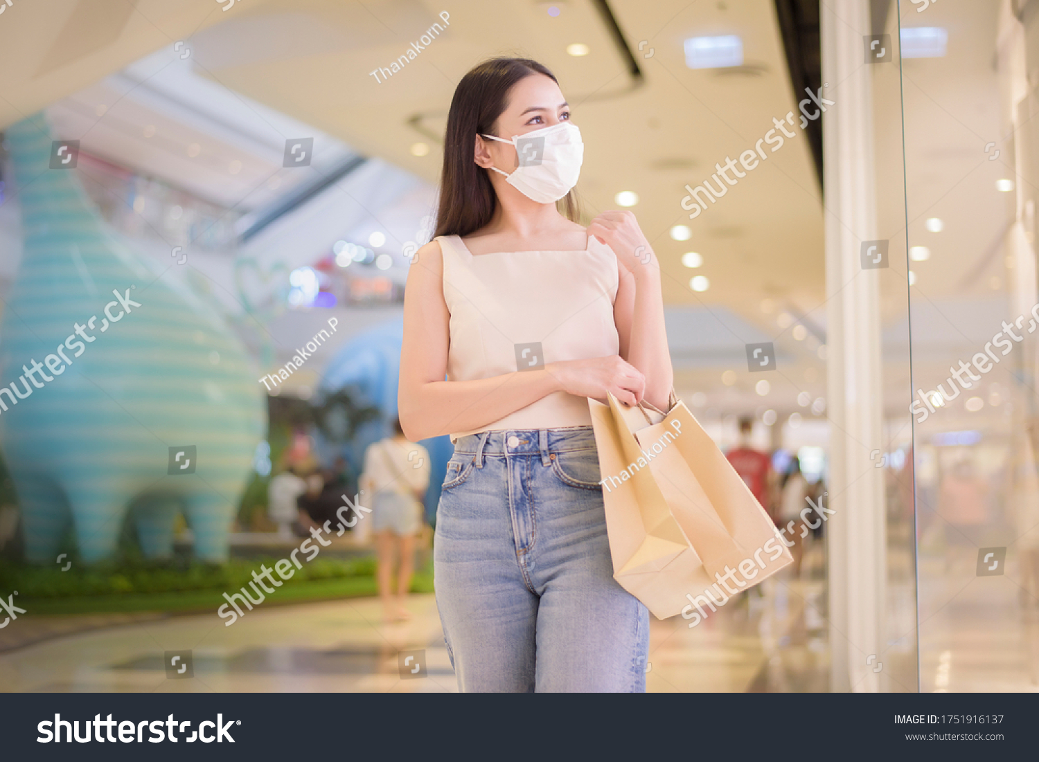 portrait of beautiful woman is wearing face mask in shopping center  #1751916137