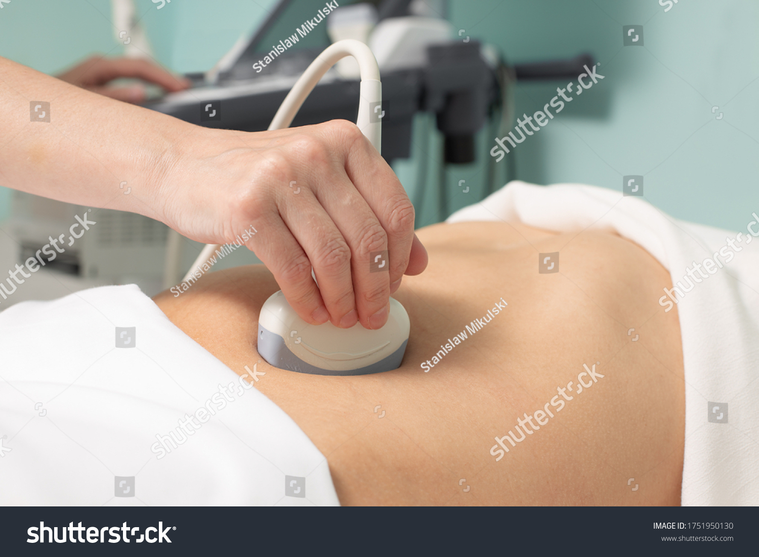 Doctor conducting ultrasound examination of woman in clinic #1751950130