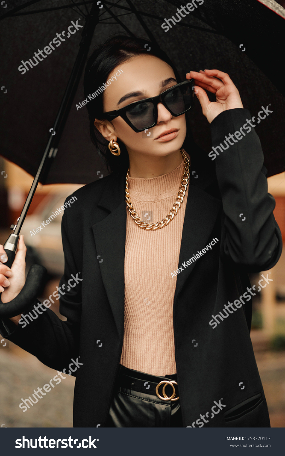 Young girl makes emotion.Dressed in a black shirt, black sweater, black hat, glasses and bright lips, fashion clothes.Wear vintage sunglasses, outfit and hat, leisure style, bright colors.Sensual woma #1753770113