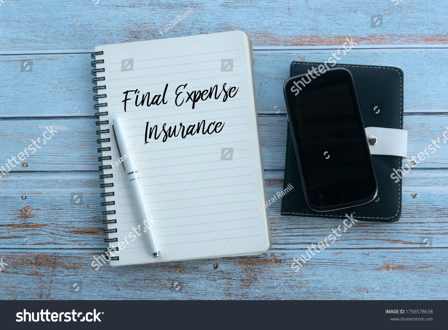 Top view of mobile phone,pen and notebook written with Final Expense Insurance on wooden background. #1756578638