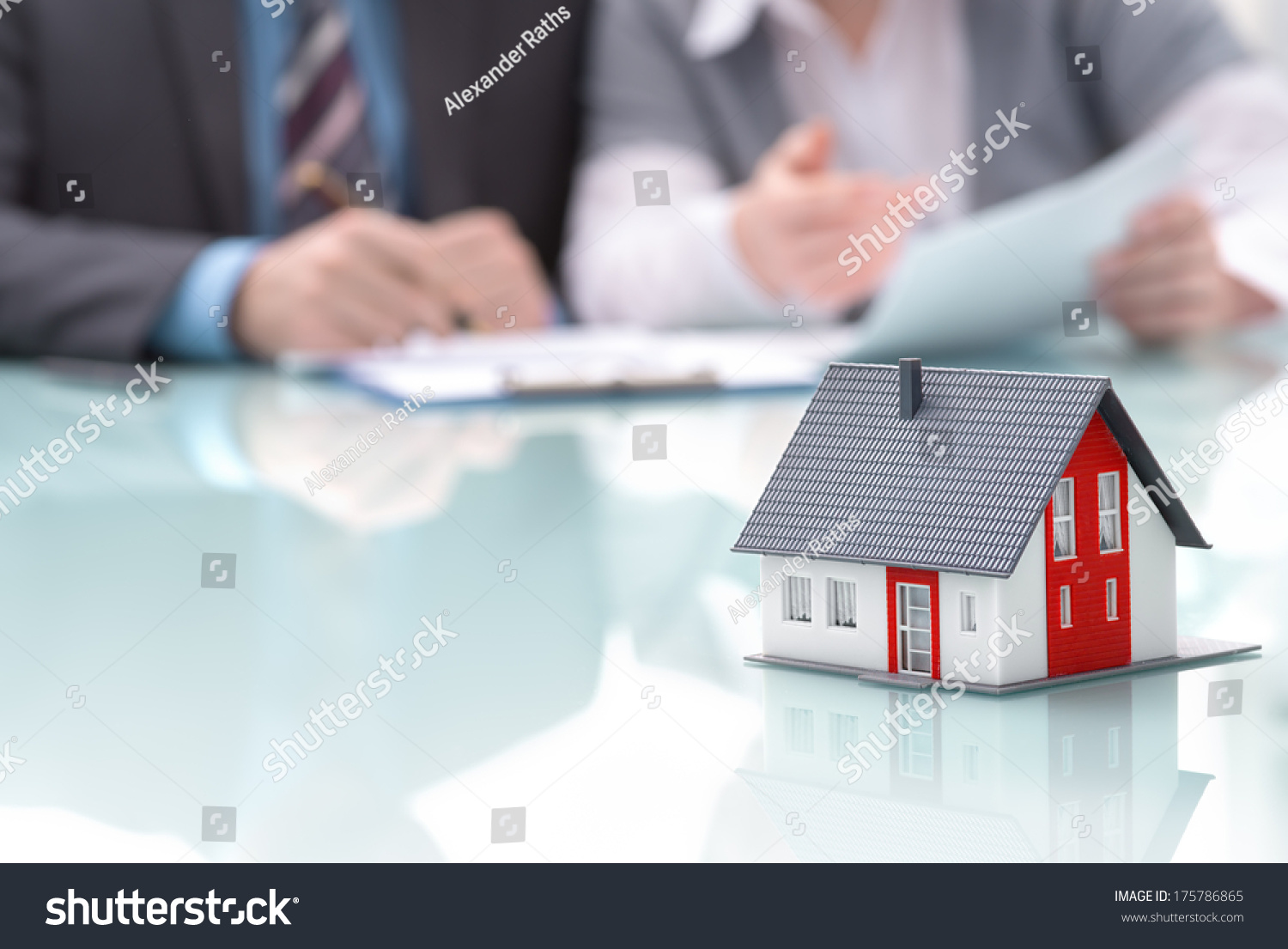 Businessman signs contract behind home architectural model #175786865