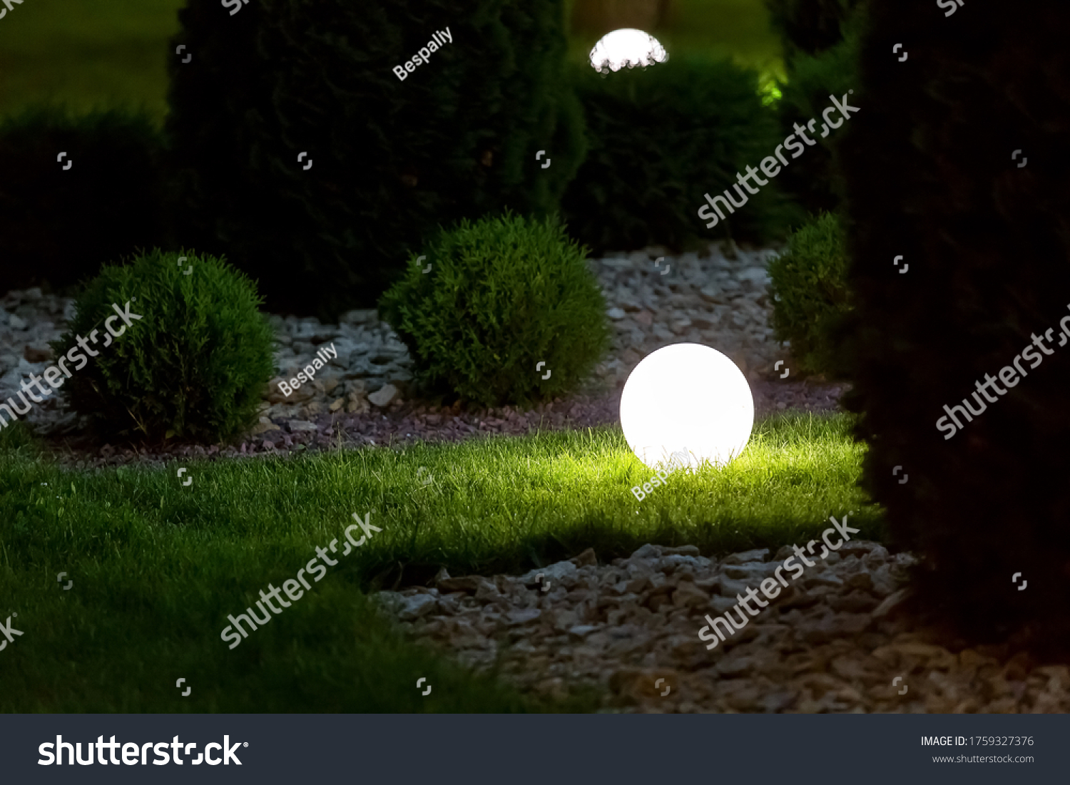 illumination backyard light garden with electric ground lantern with round diffuser lamp in lawn in outdoor park with landscaping thuja bushes in stone mulching, dark illuminate night scene nobody. #1759327376