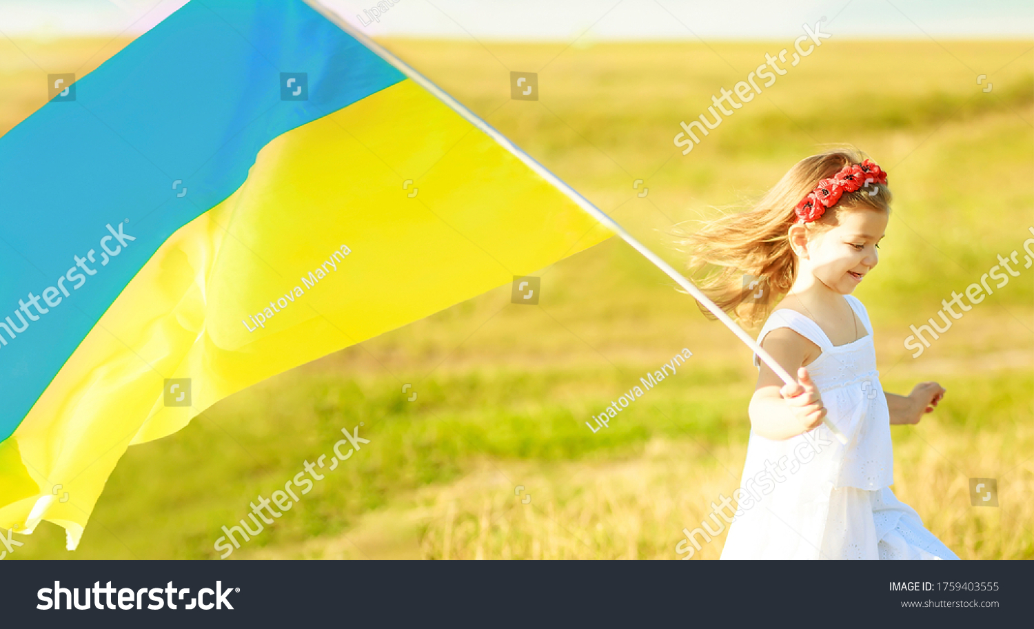Ukraine s blue-yellow flag flying in wind in hands of little Ukrainian girl on Day of independence of Ukraine. Symbols of Ukraine in hands of a smiling child. Constitution day Ukraine. Soft focus #1759403555