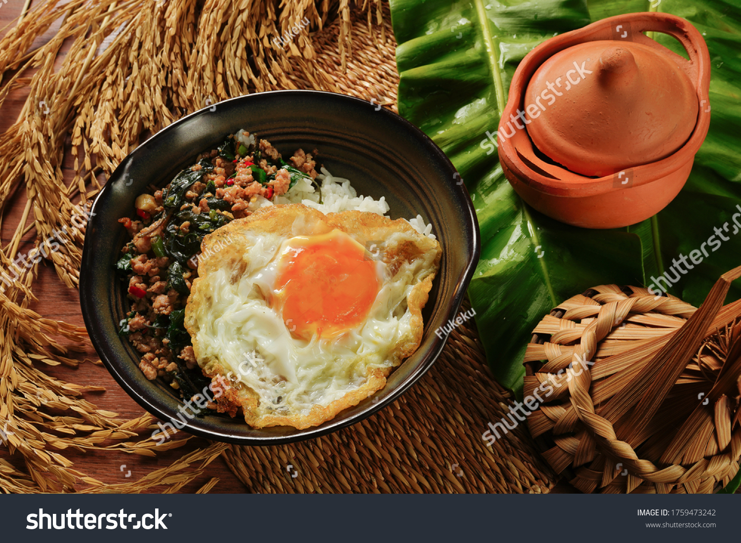 Stir-fried Minced pork with basil and 
fried egg or Thai Food Rice topped with stir-fried pork and basil and 
fried egg is the popular in Thailand with ancient background, Thai street food. #1759473242