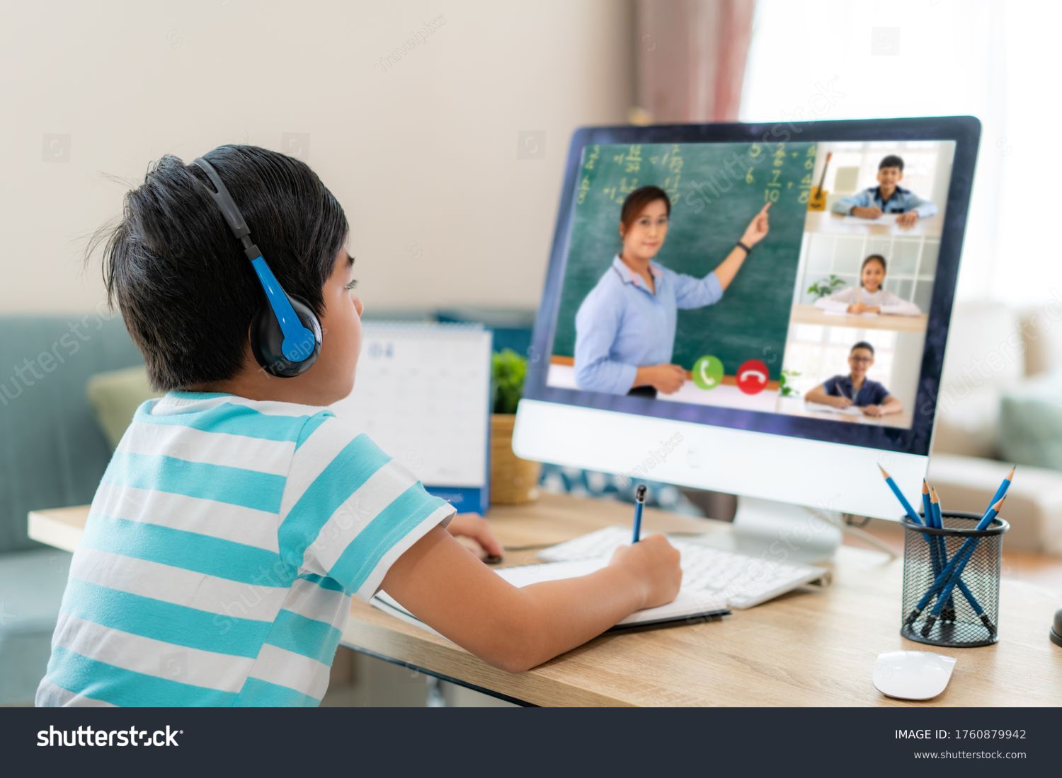 Asian boy student video conference e-learning with teacher and classmates on computer in living room at home. Homeschooling and distance learning ,online ,education and internet. #1760879942