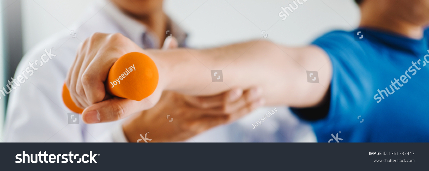 Physiotherapist man giving exercise with dumbbell treatment About Arm and Shoulder of athlete male patient Physical therapy concept #1761737447