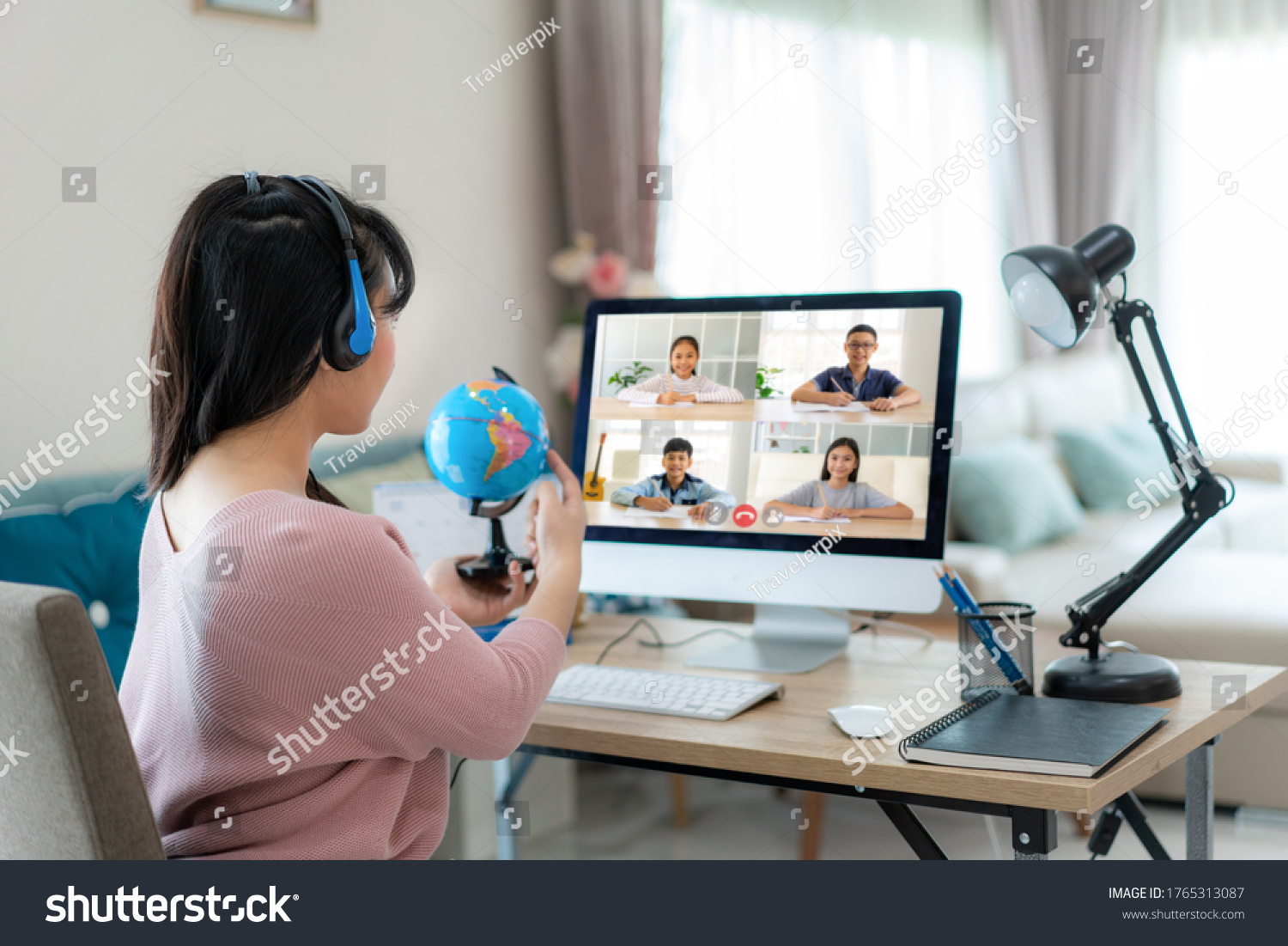 Asian woman teacher teaching geography via video conference e-learning and cheerful elementary school student looking at globe, Homeschooling and distance learning ,online ,education and internet. #1765313087