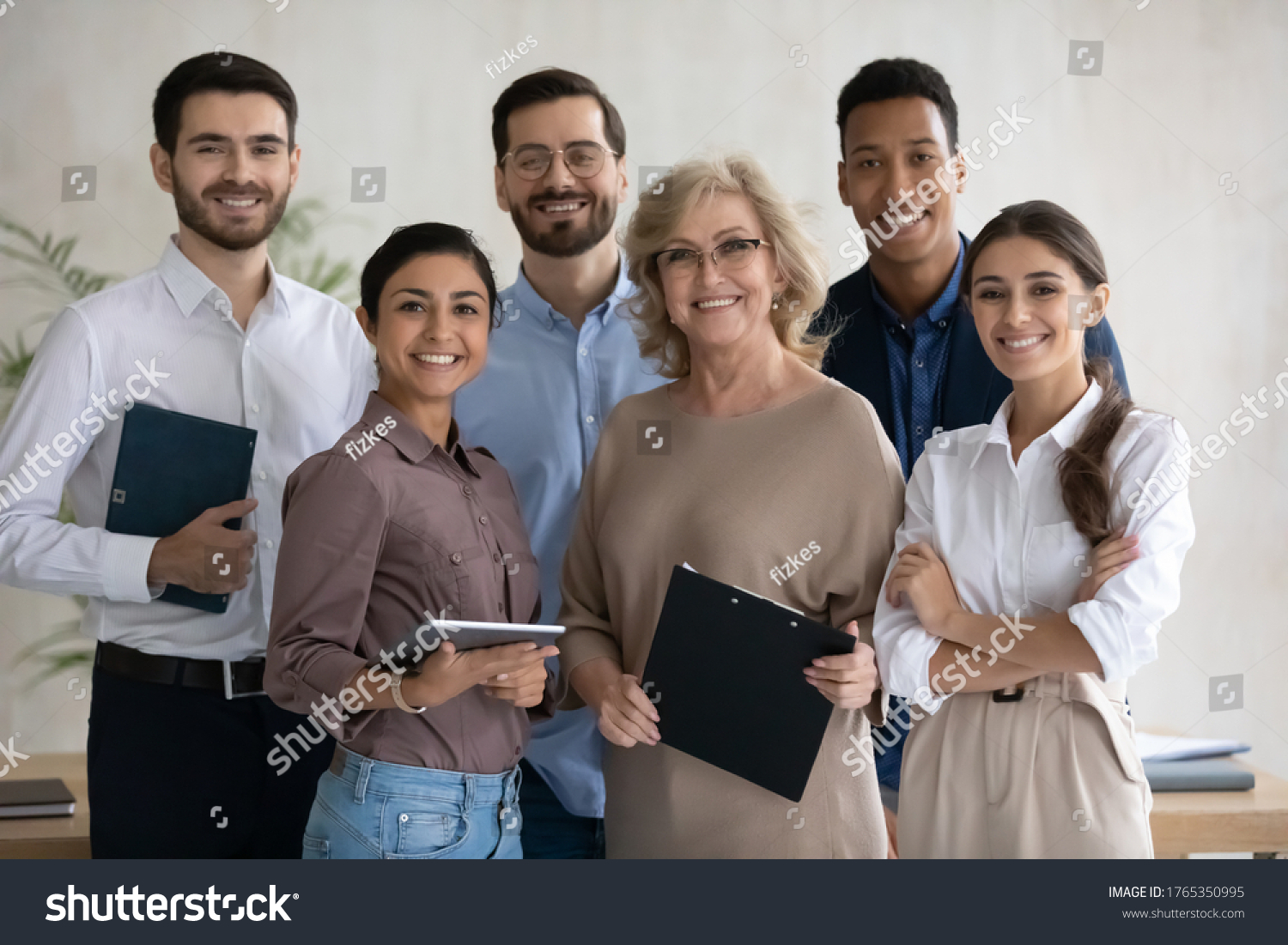Corporate portrait smiling diverse employees team standing in office, looking at camera, successful happy workers with middle aged leader posing for photo, motivated staff, workforce #1765350995