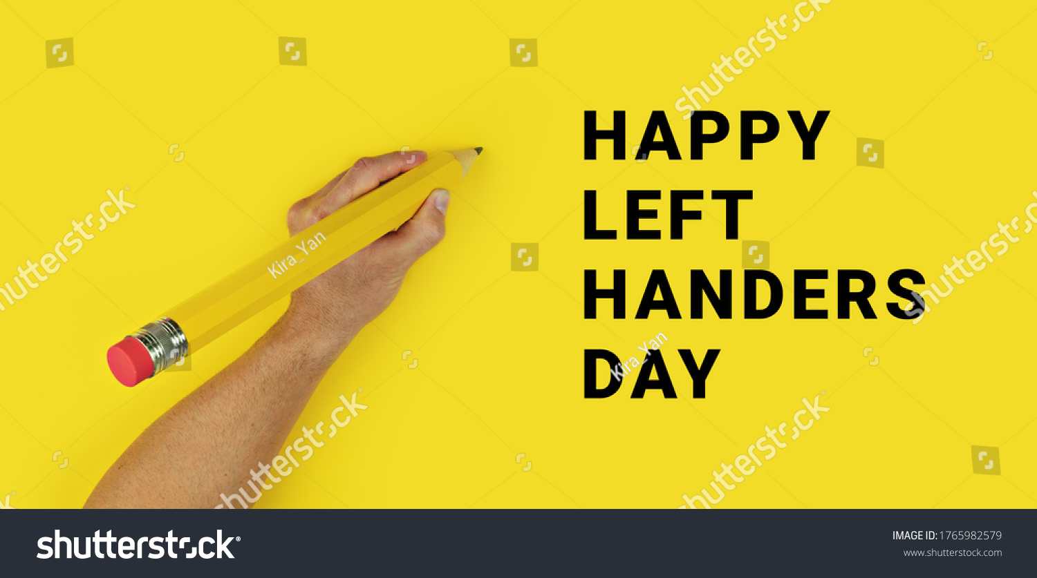 Big pencil in male left hand on yellow background with text Happy Left Handers Day. Conceptual banner for celebration of international left-handed day #1765982579