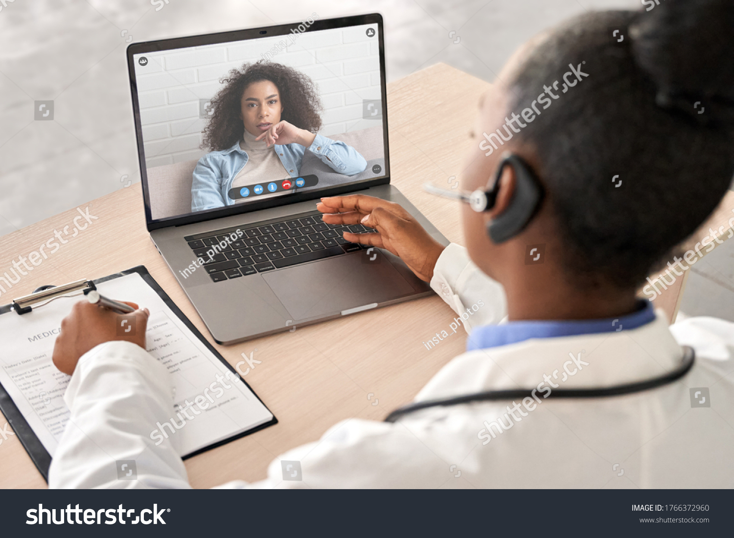 African doctor wear headset consult female black patient make online webcam video call on laptop screen. Telemedicine videoconference remote computer app virtual meeting. Over shoulder videocall view. #1766372960