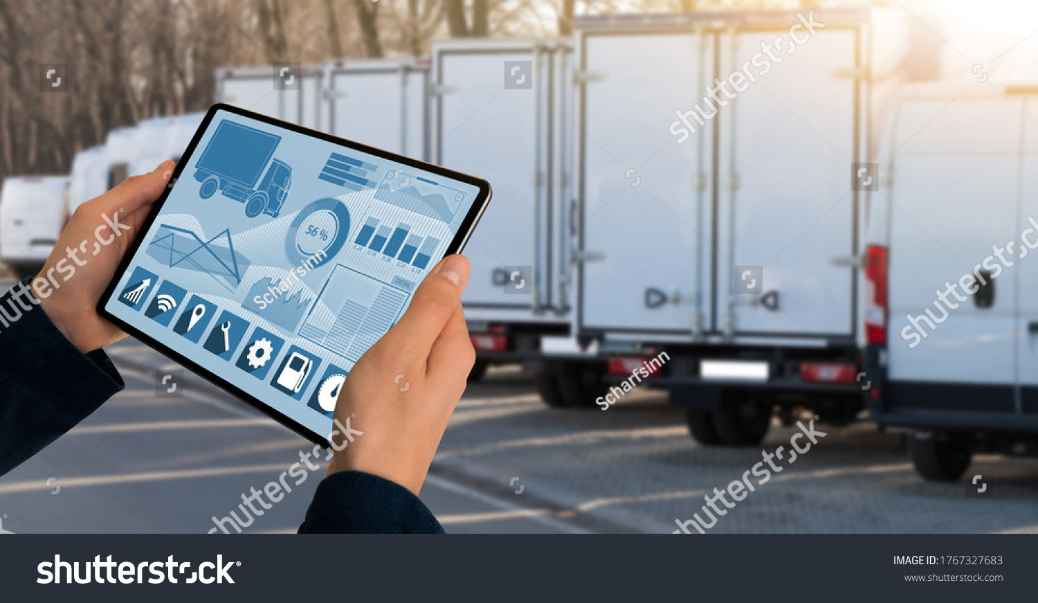 Manager with a digital tablet on the background of trucks. Fleet management #1767327683
