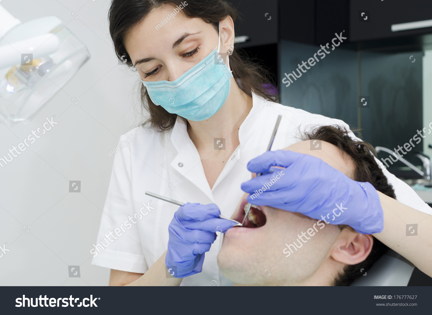 Young male with open mouth during oral checkup at the dentist #176777627