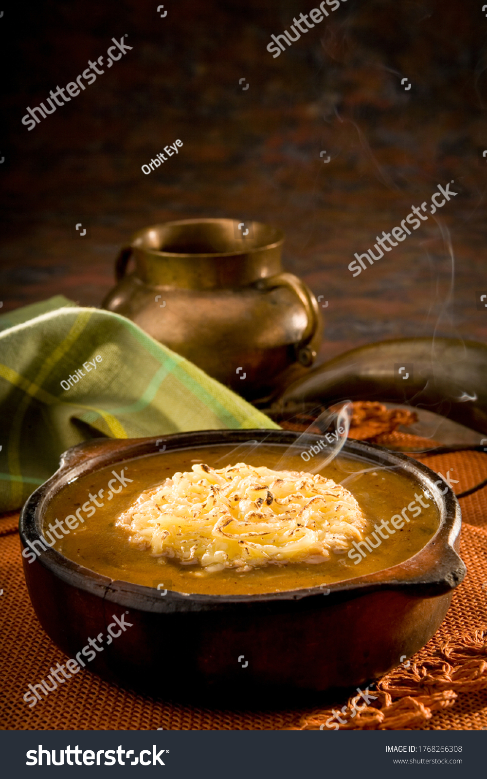 Bowl of onion soup with a napkin and a bowl in the background. Traditional Ecuadorian soup in a cozy and warm setup. #1768266308