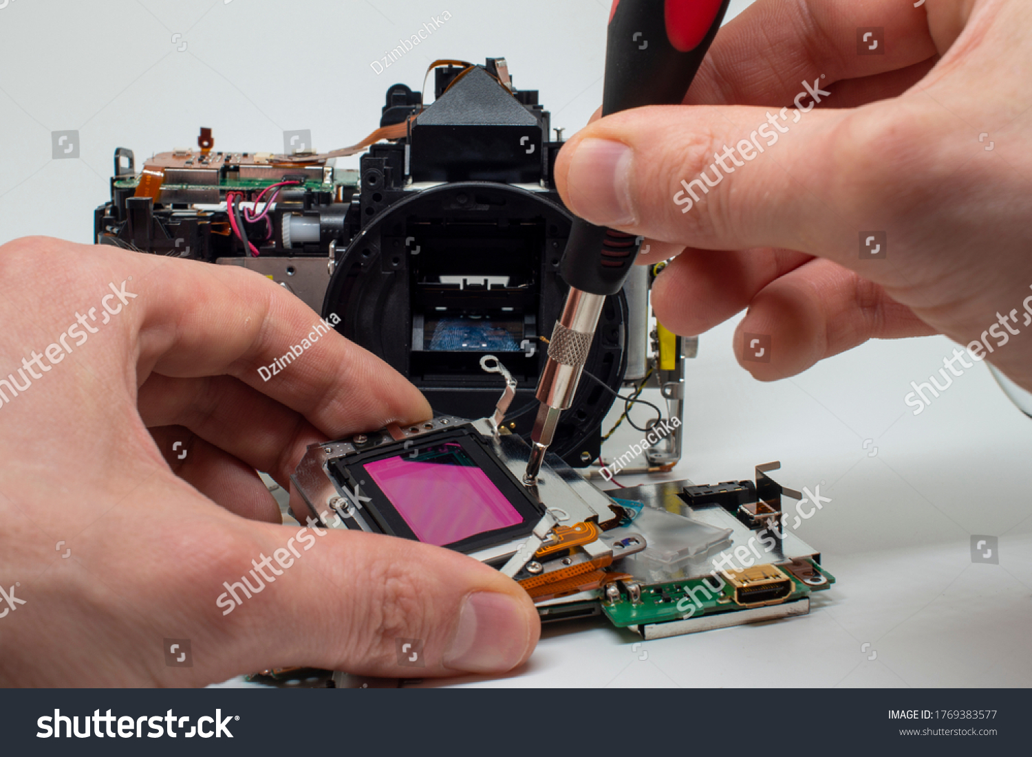 Taking apart and repairing digital camera. Close up image of camera parts. #1769383577