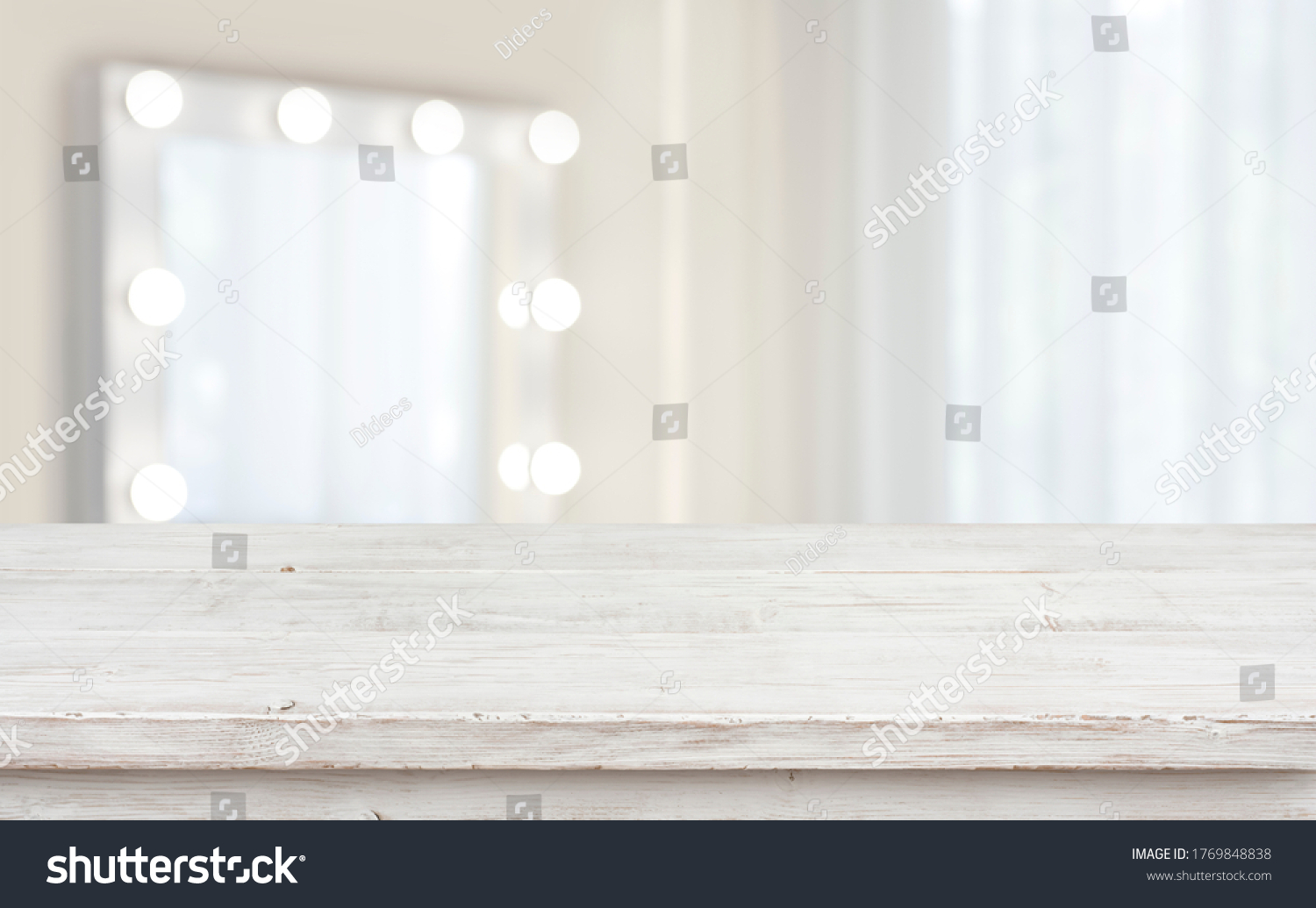 Defocused makeup mirror in dressing room with wooden table top #1769848838