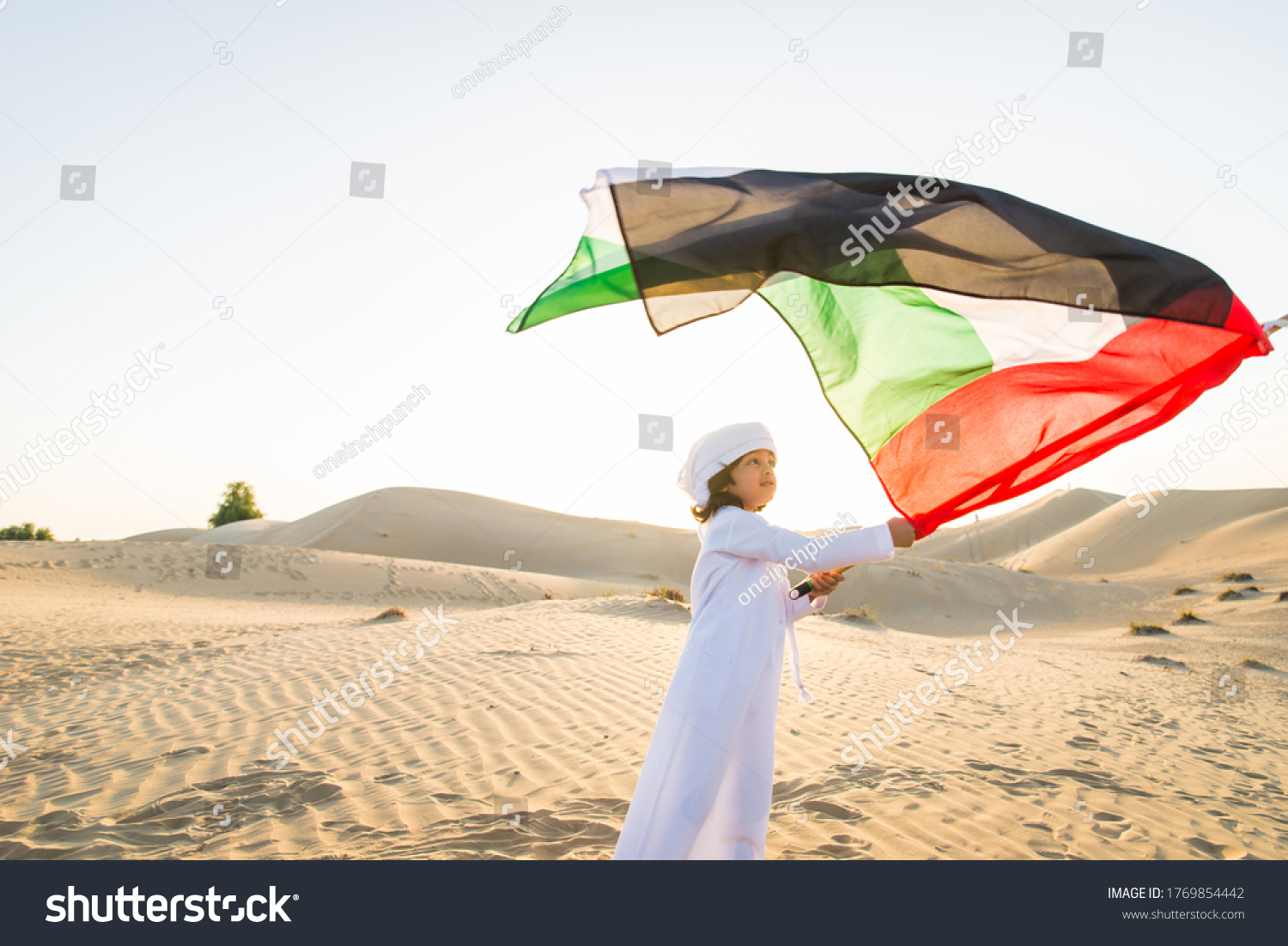 Arabian family with kids having fun in the desert - Parents and children celebrating holiday in the Dubai desrt #1769854442