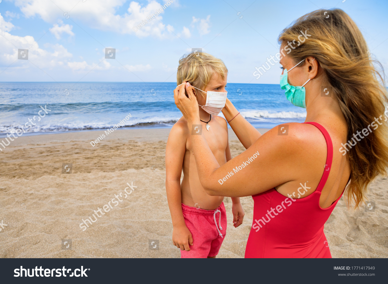 Mother put medical mask on child on sea beach. New rules to wear cloth face covering at public places. Cancelled cruise, tour due coronavirus COVID 19. Family vacation, travel lifestyle at summer 2020 #1771417949
