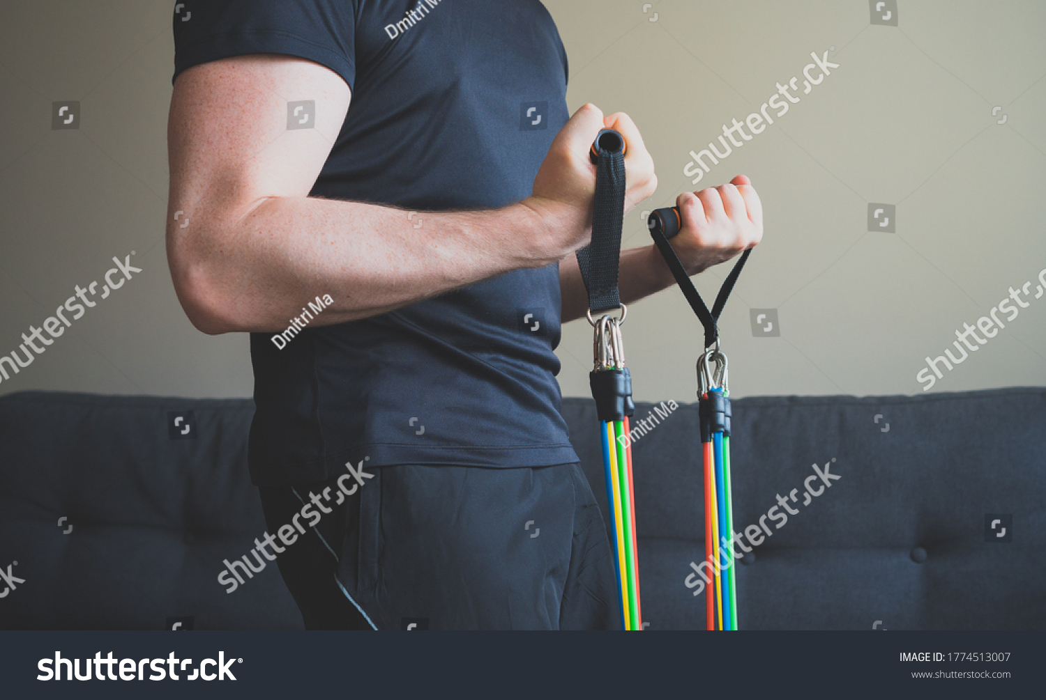 Man doing exercises with resistance bands at home. #1774513007