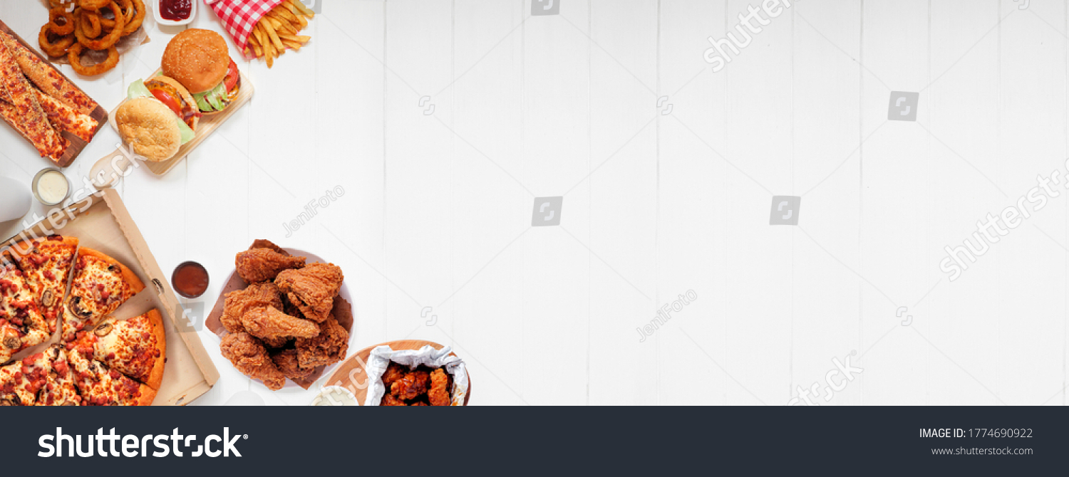 Selection of take out and fast foods. Corner border banner. Pizza, hamburgers, fried chicken and sides.  Top down view on a white wood background with copy space. #1774690922
