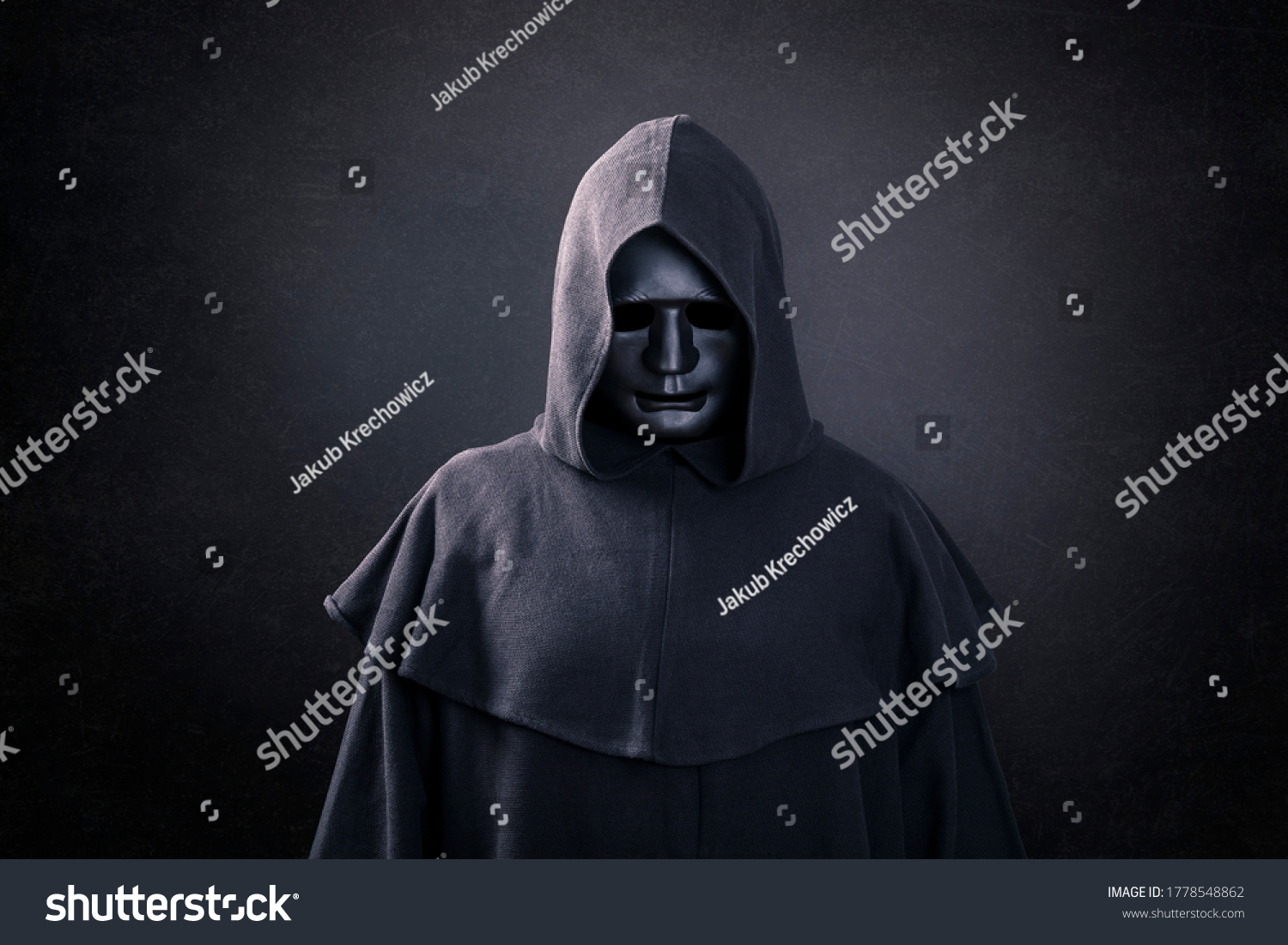 Scary figure with mask in hooded cloak in the dark #1778548862