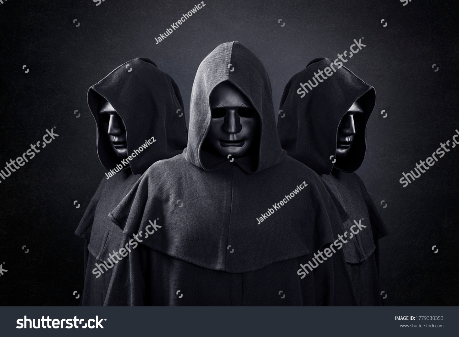 Group of three scary figures in hooded cloaks in the dark #1779330353