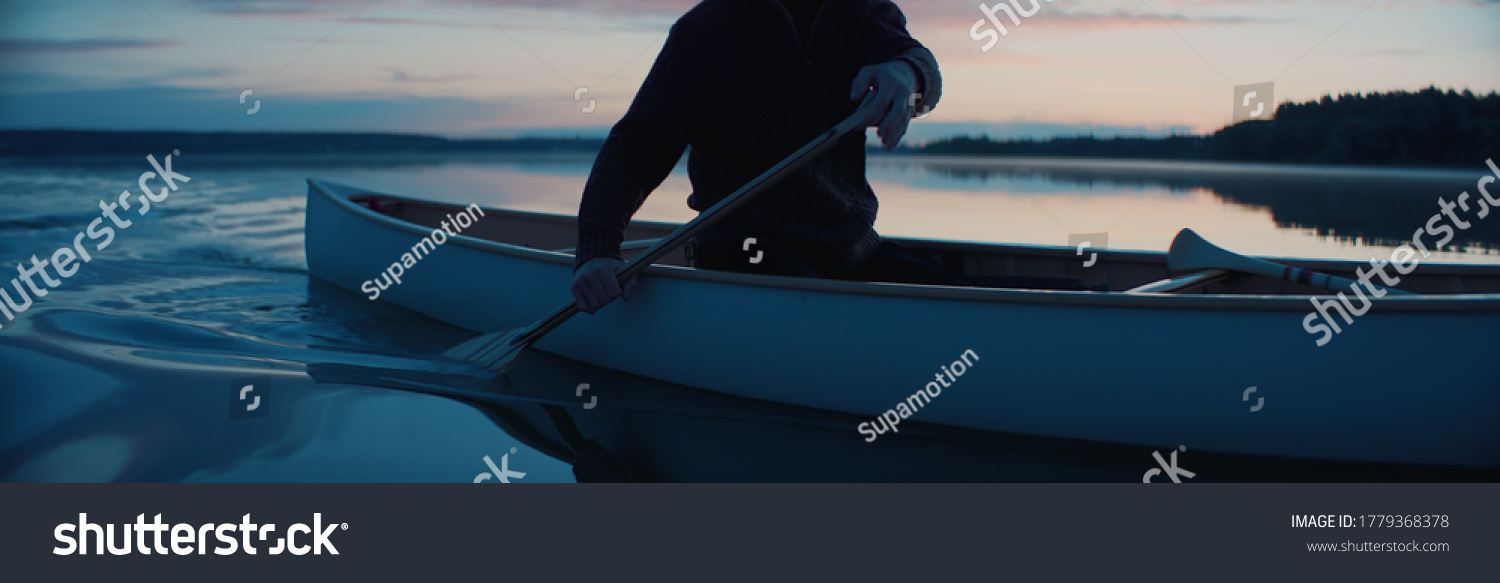 CU view of a paddle, man canoeing alone boat on a large lake at dawn #1779368378