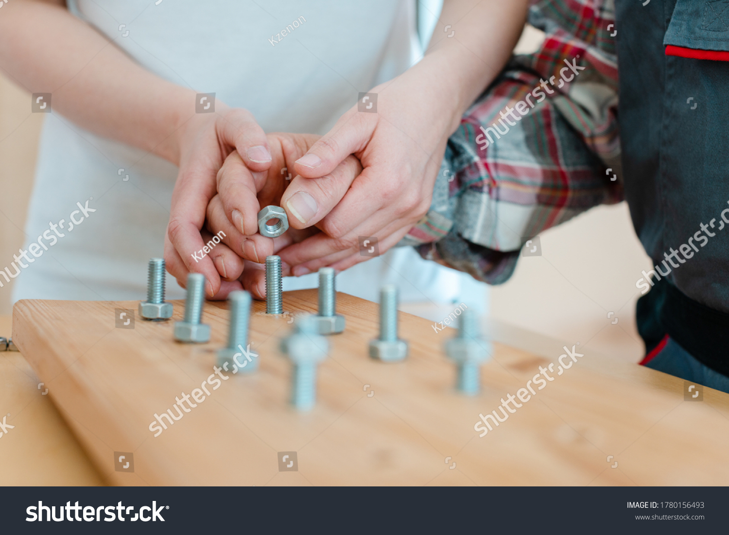 Closeup on hand of man in occupational therapy screwing nut on bolt #1780156493