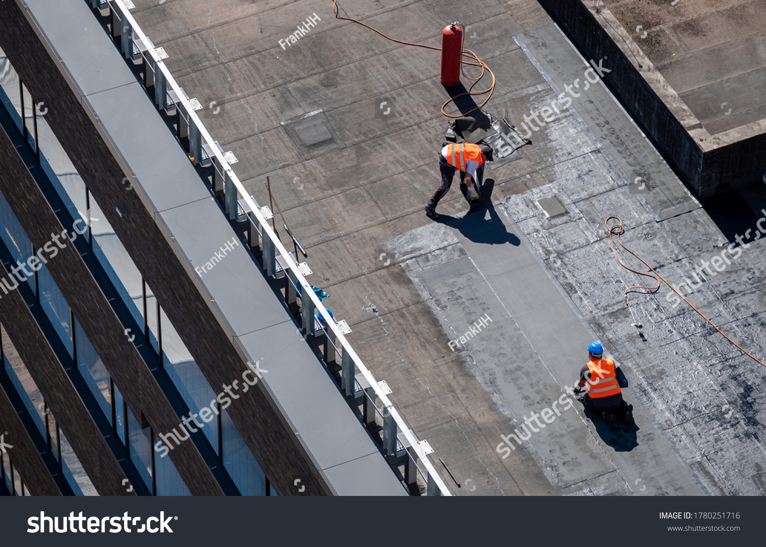 Birds eye view of a roof construction site. Professional bitumen waterproofing on a flat building. #1780251716