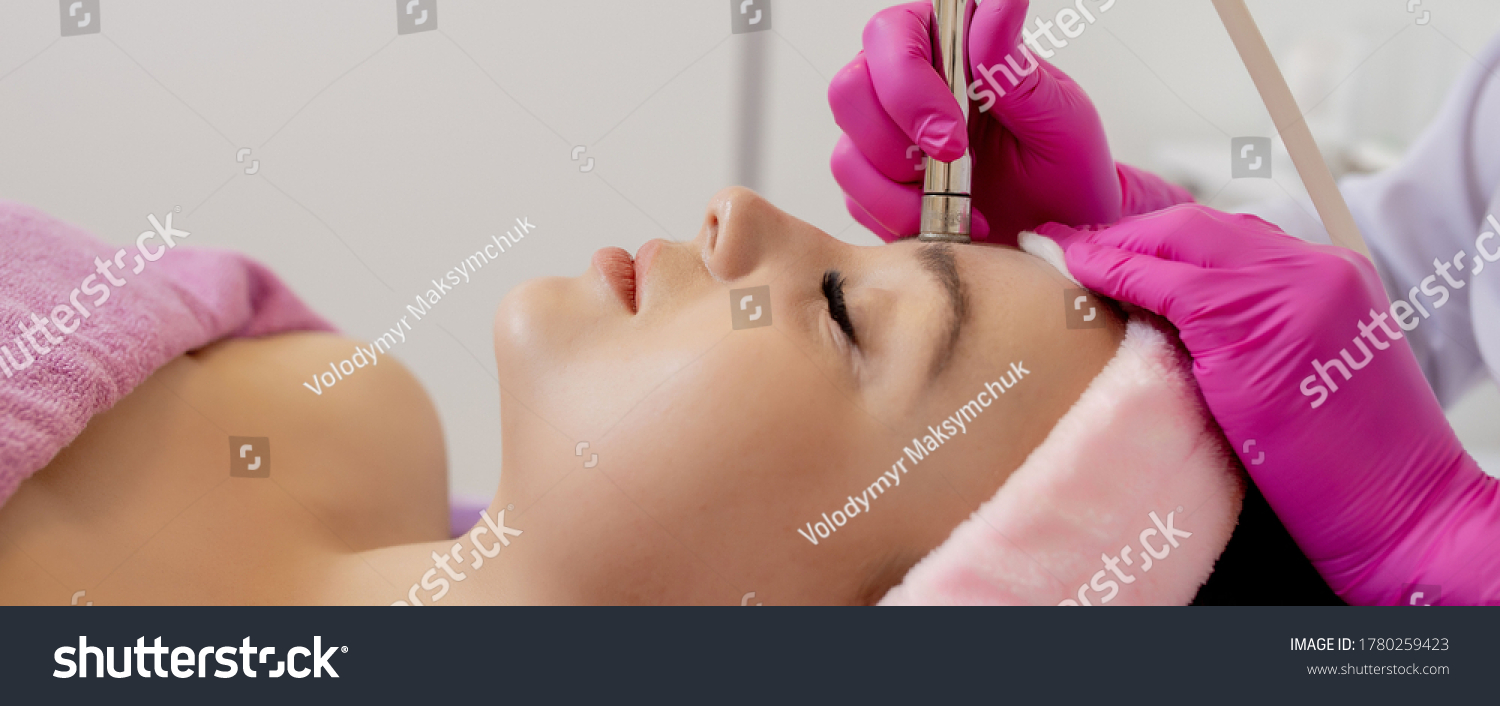 The cosmetologist makes the procedure Microdermabrasion of the facial skin of a beautiful, young woman in a beauty salon.Cosmetology and professional skin care #1780259423