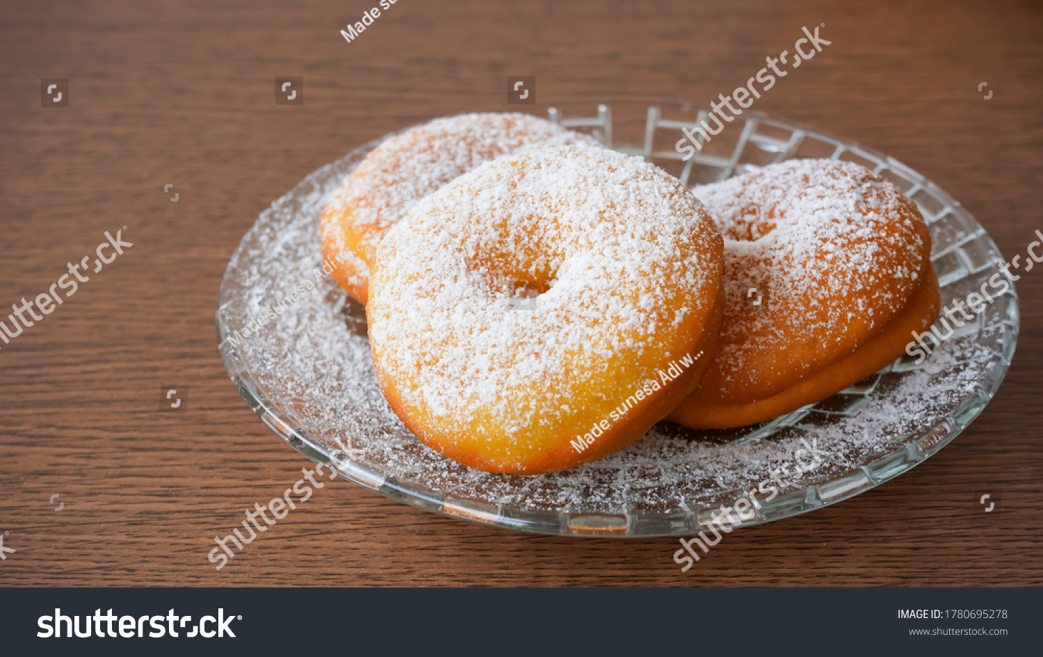 Donuts sprinkled with powdered sugar on a plate #1780695278