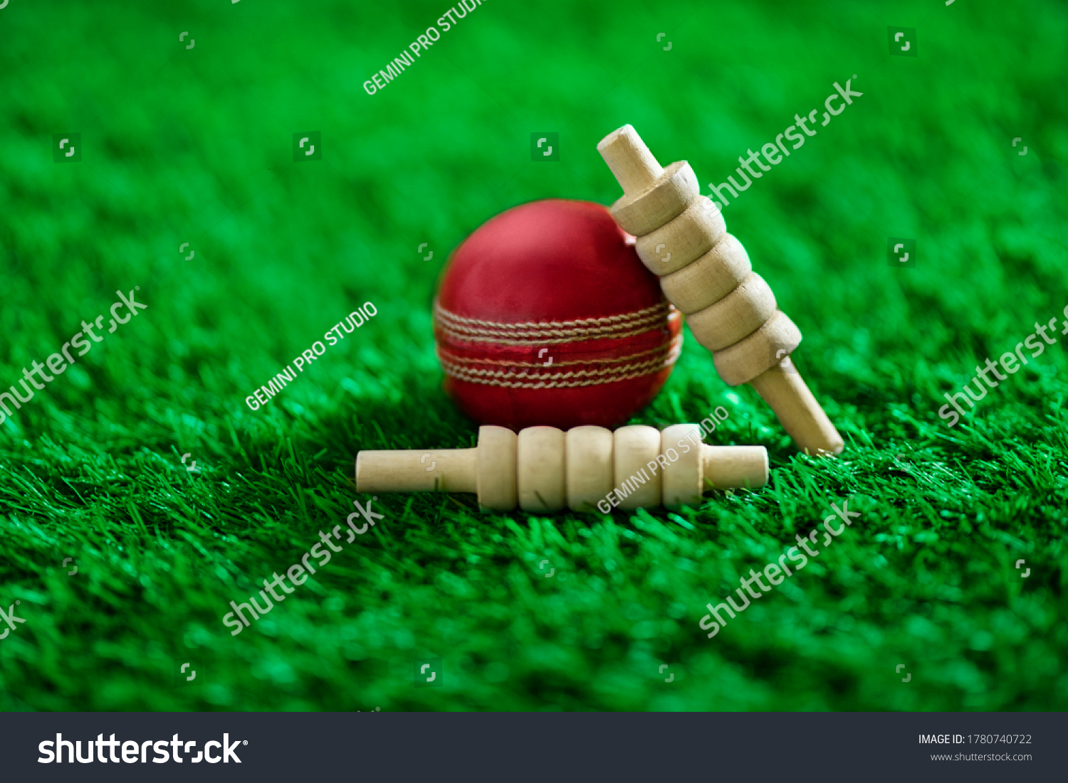 cricket ball and bails on green grass pitch #1780740722