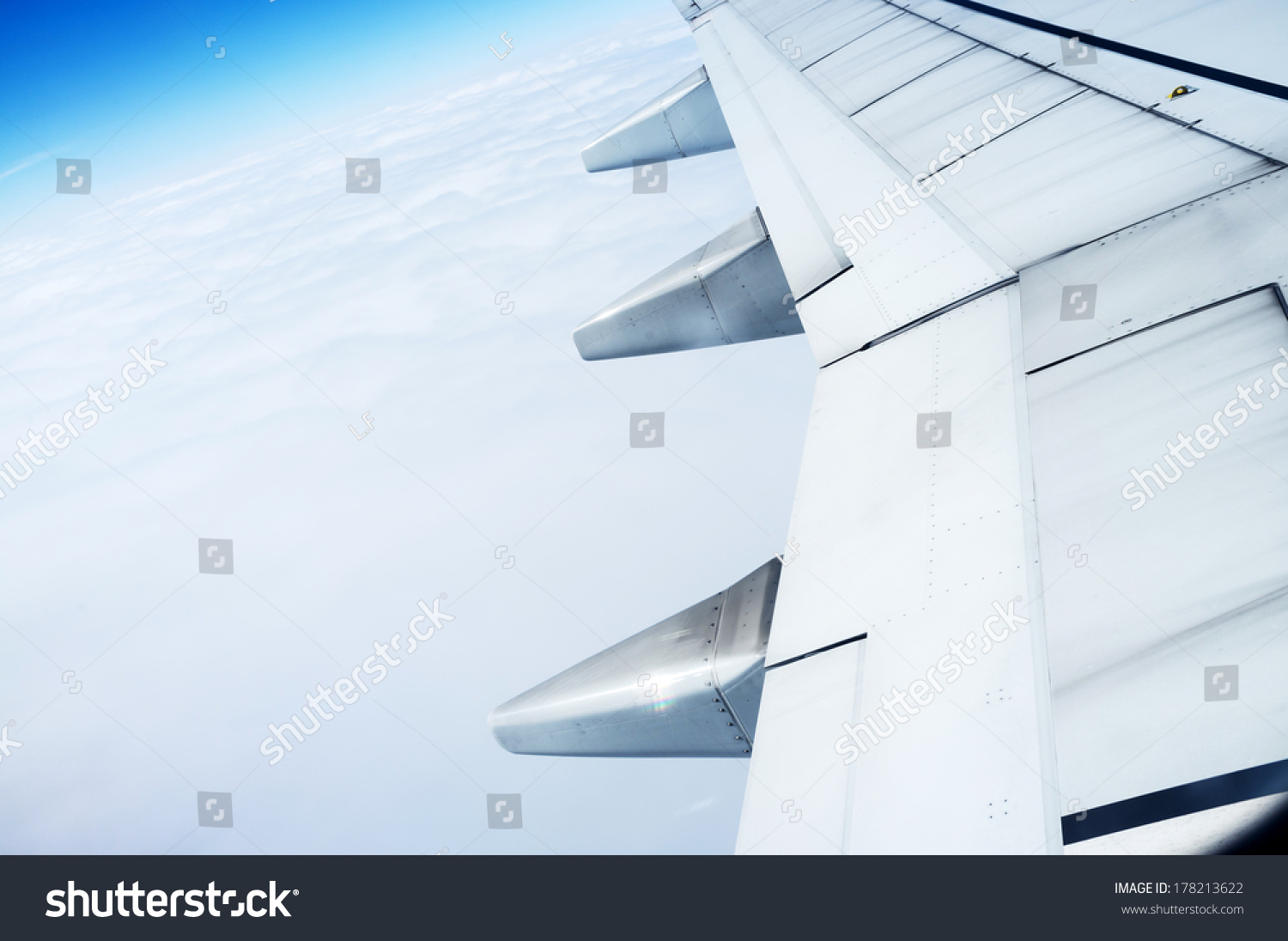 The plane's wings, the background is blue sky, taken from the cabin #178213622