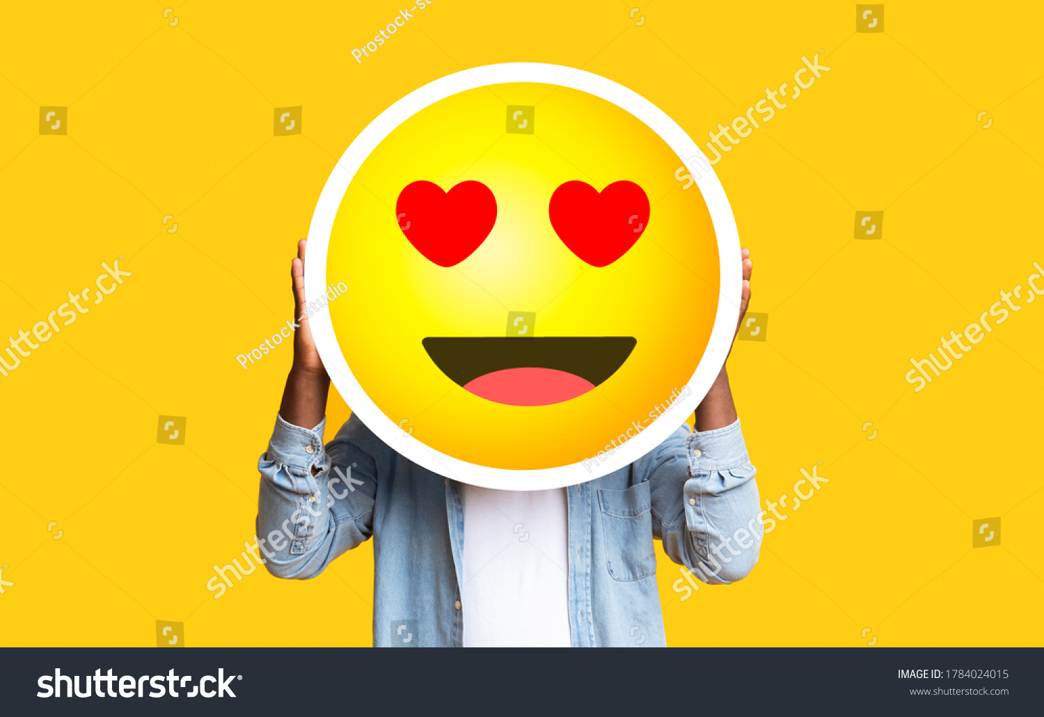 I Love Emoji. Unrecognizable Black Man Hiding Face Against Romantic Emoticon Sticker, Standing Over Yellow Background With Free Space #1784024015