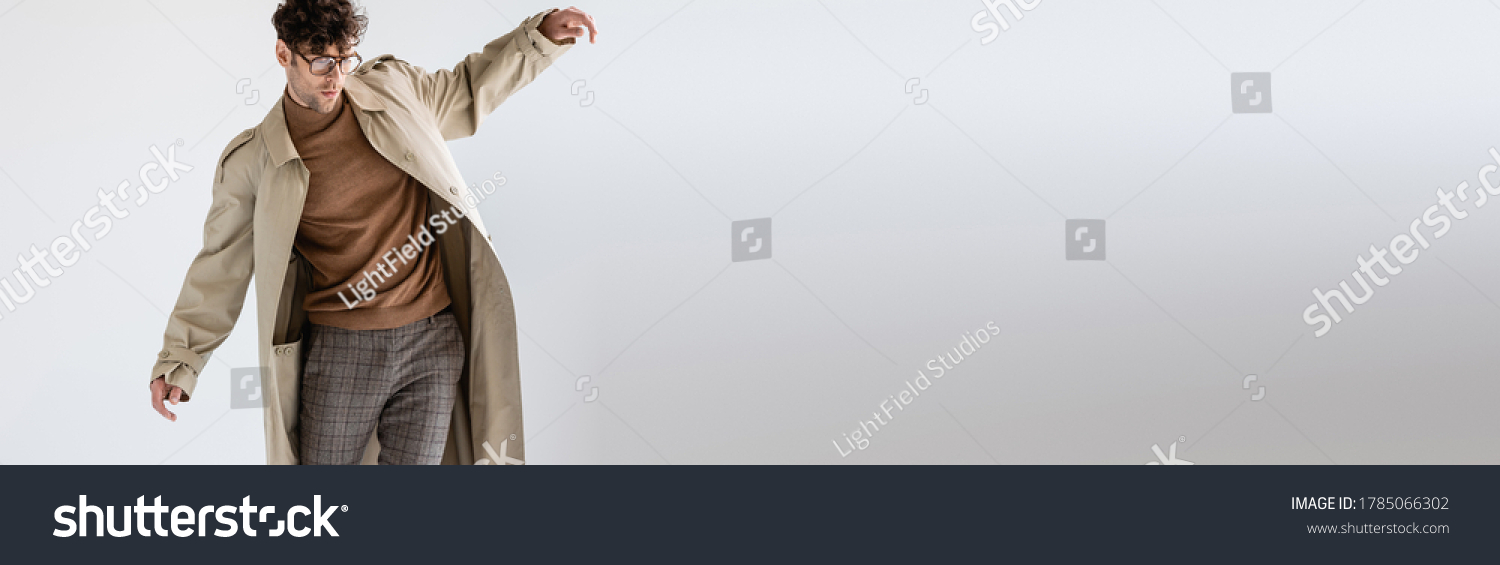 website header of fashionable man balancing while posing on grey #1785066302