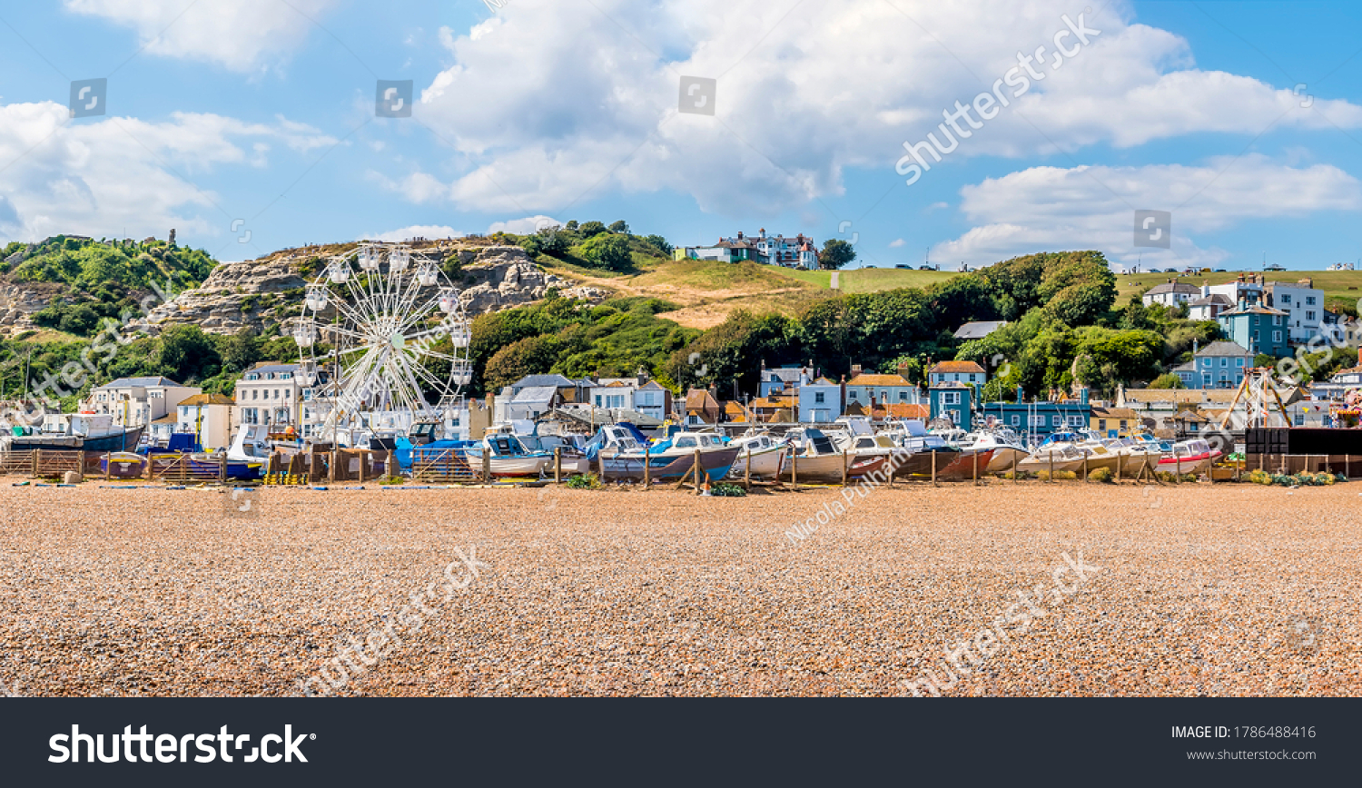 A panorama view of the old town beach in Hastings, Sussex with the west cliff backdrop in summer #1786488416