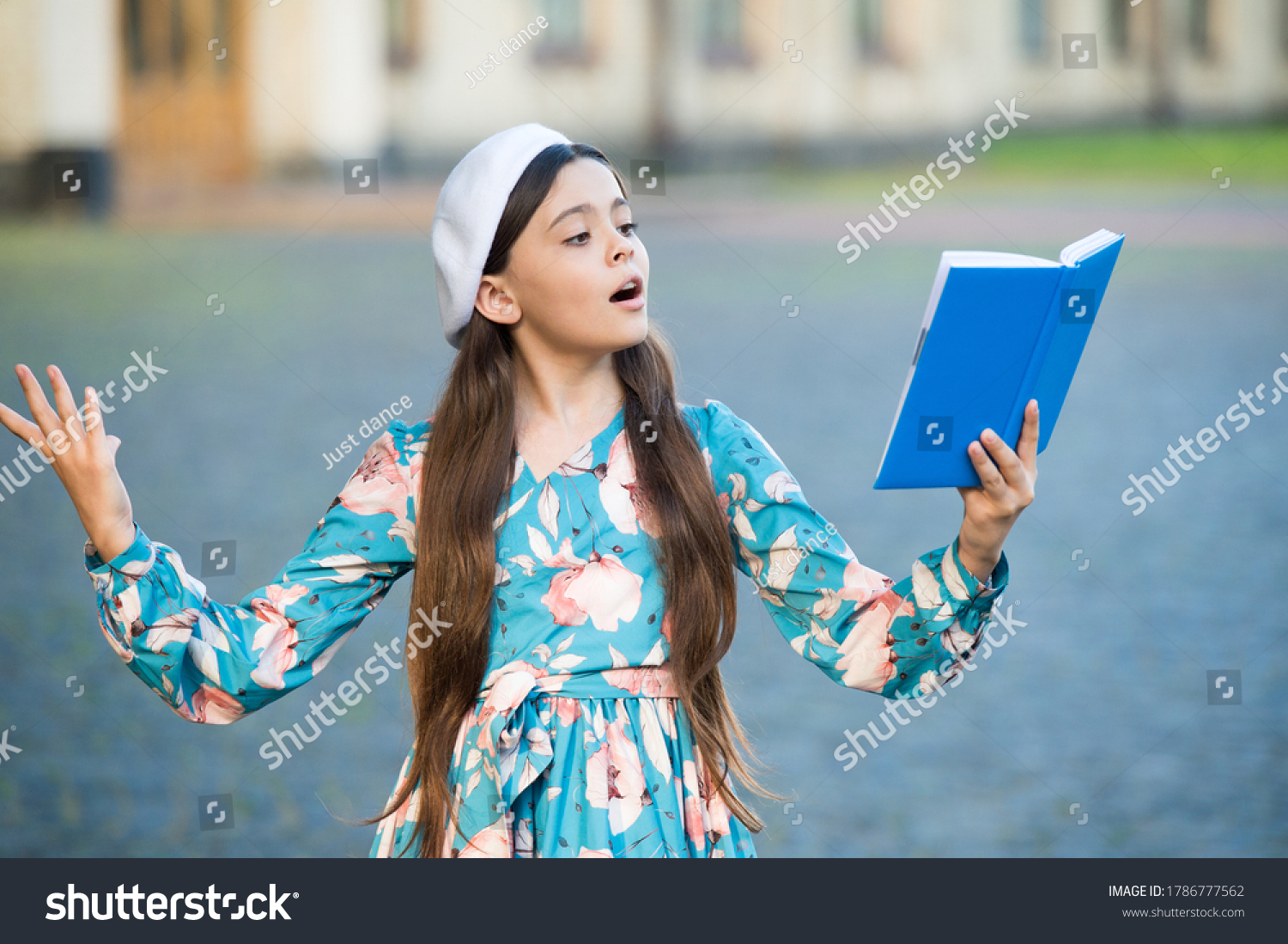 Girl student reading book outdoors, recite poetry concept. #1786777562