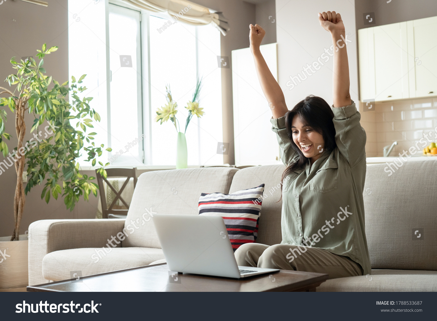 Excited indian woman celebrating online win success looking at laptop at home. Happy euphoric indian lady student, lottery winner raising hands get new job opportunity, watching game on computer. #1788533687