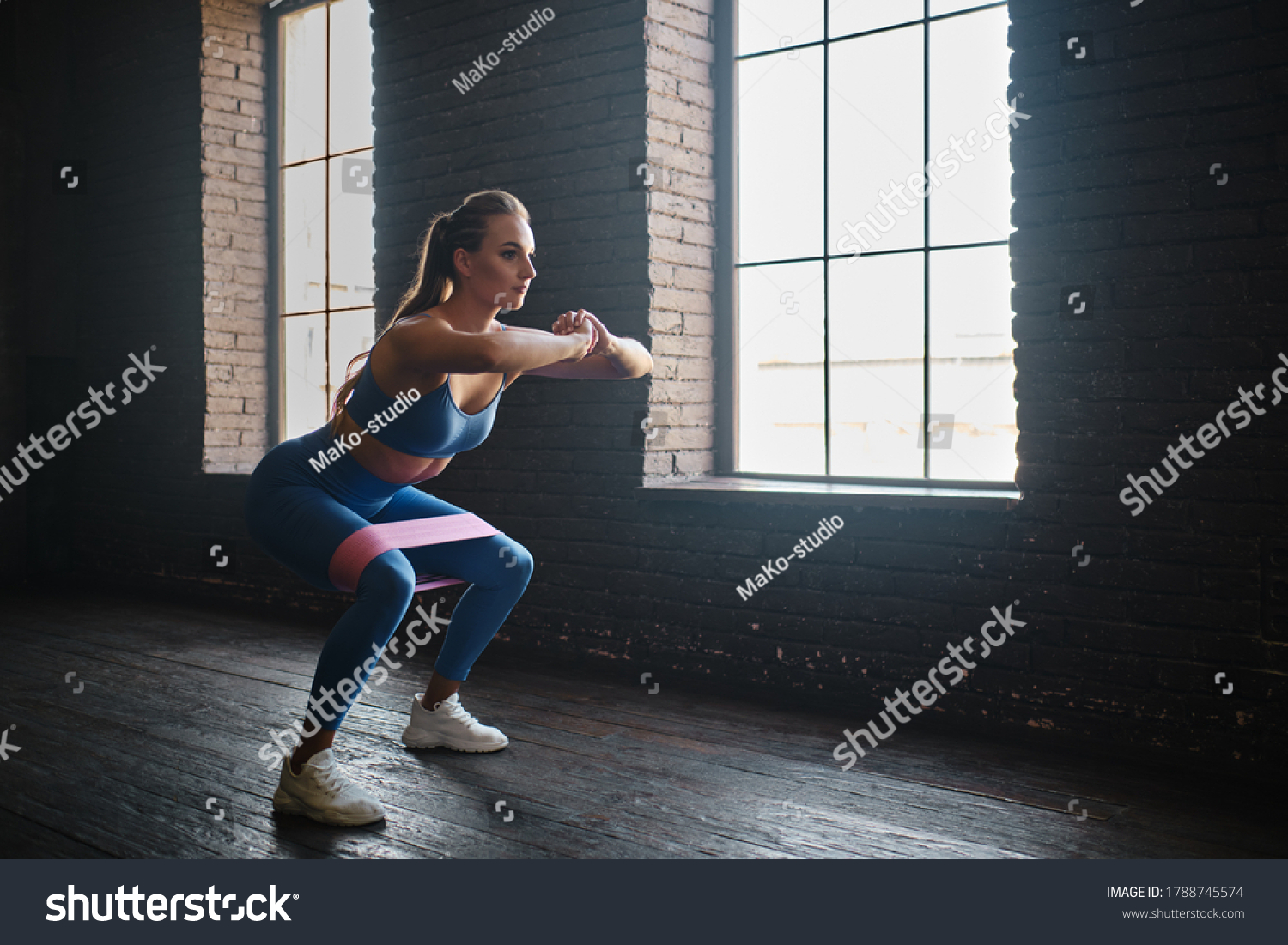 Crossfit healthy concept. Woman wearing sport clothing using resistance band #1788745574