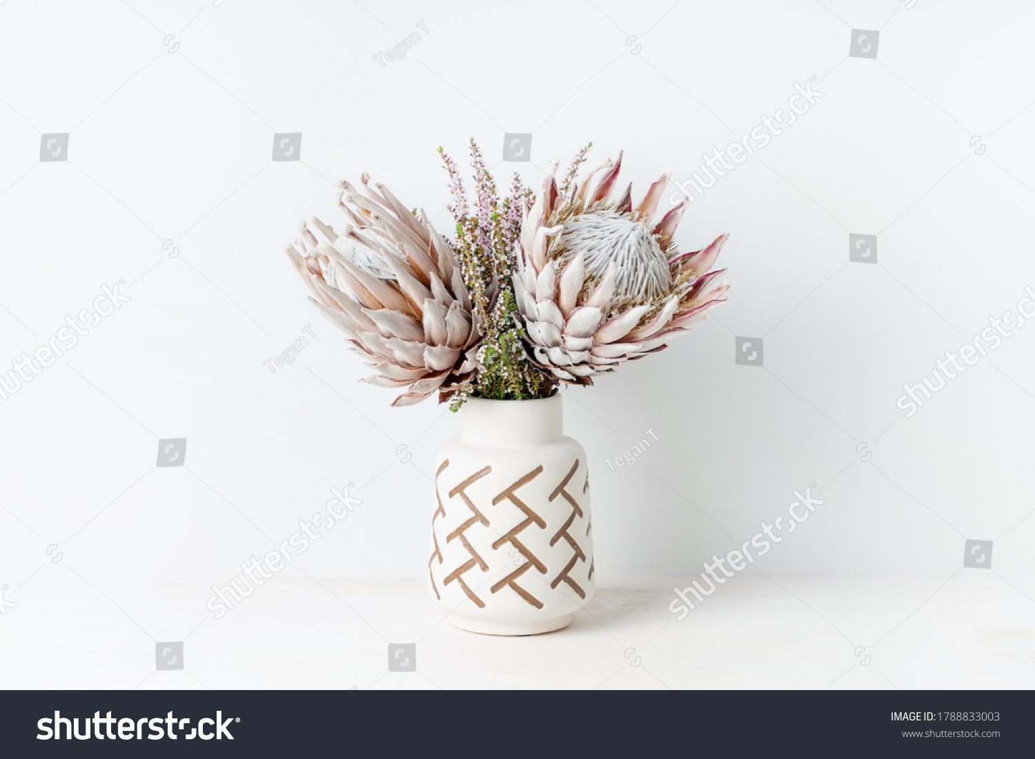 Beautiful floral arrangement including beautiful dried pink King Proteas and delicate thryptomene flowers, in a stylish aztec vase. #1788833003