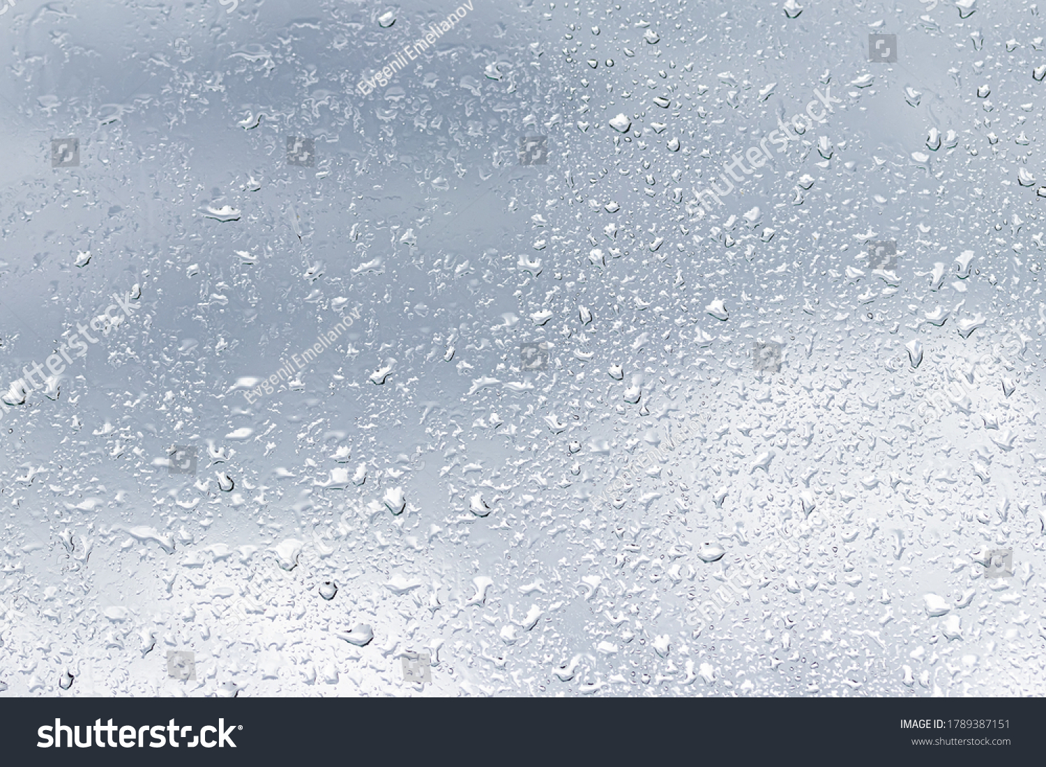 Rain drops on window glasses surface with cloudy background . Natural backdrop of raindrops. Abstract overlay for design. The concept of bad rainy weather. #1789387151