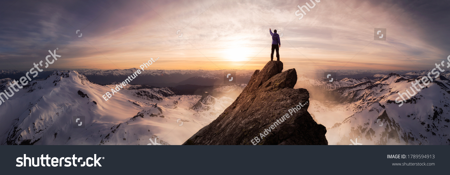 Magical Fantasy Adventure Composite of Man Hiking on top of a rocky mountain peak. Background Landscape from British Columbia, Canada. Sunset or Sunrise Colorful Sky #1789594913