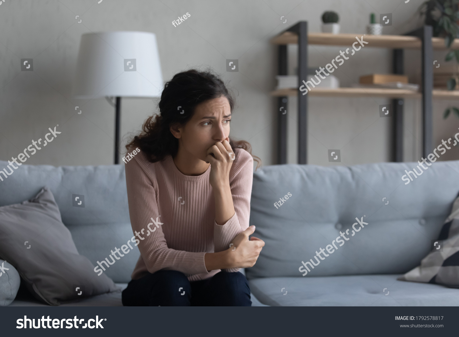 Sad young Caucasian woman sit on couch at home look in distance mourning yearning, unhappy upset female thinking suffering from relationships problems, struggle with miscarriage or abortion trouble #1792578817