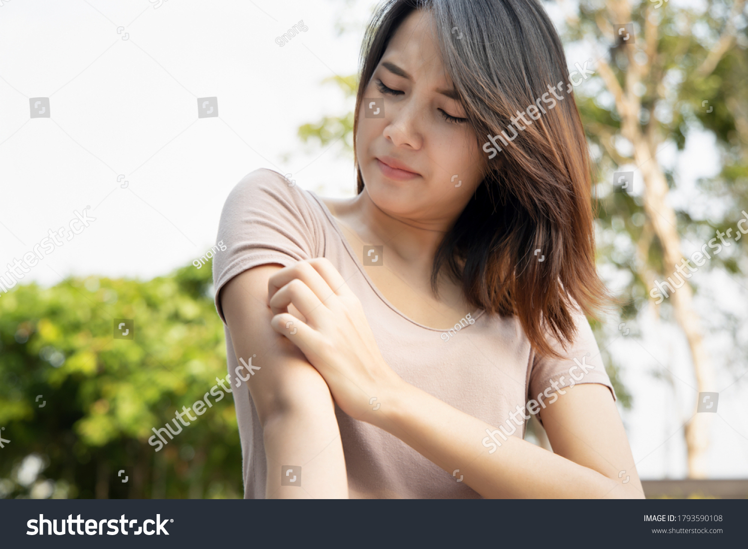 Asian woman scratching her arm; concept of dry skin, allergic skin inflammation, body care, fungus infection, eczema, dermatitis, rash, mosquito or insect bite #1793590108