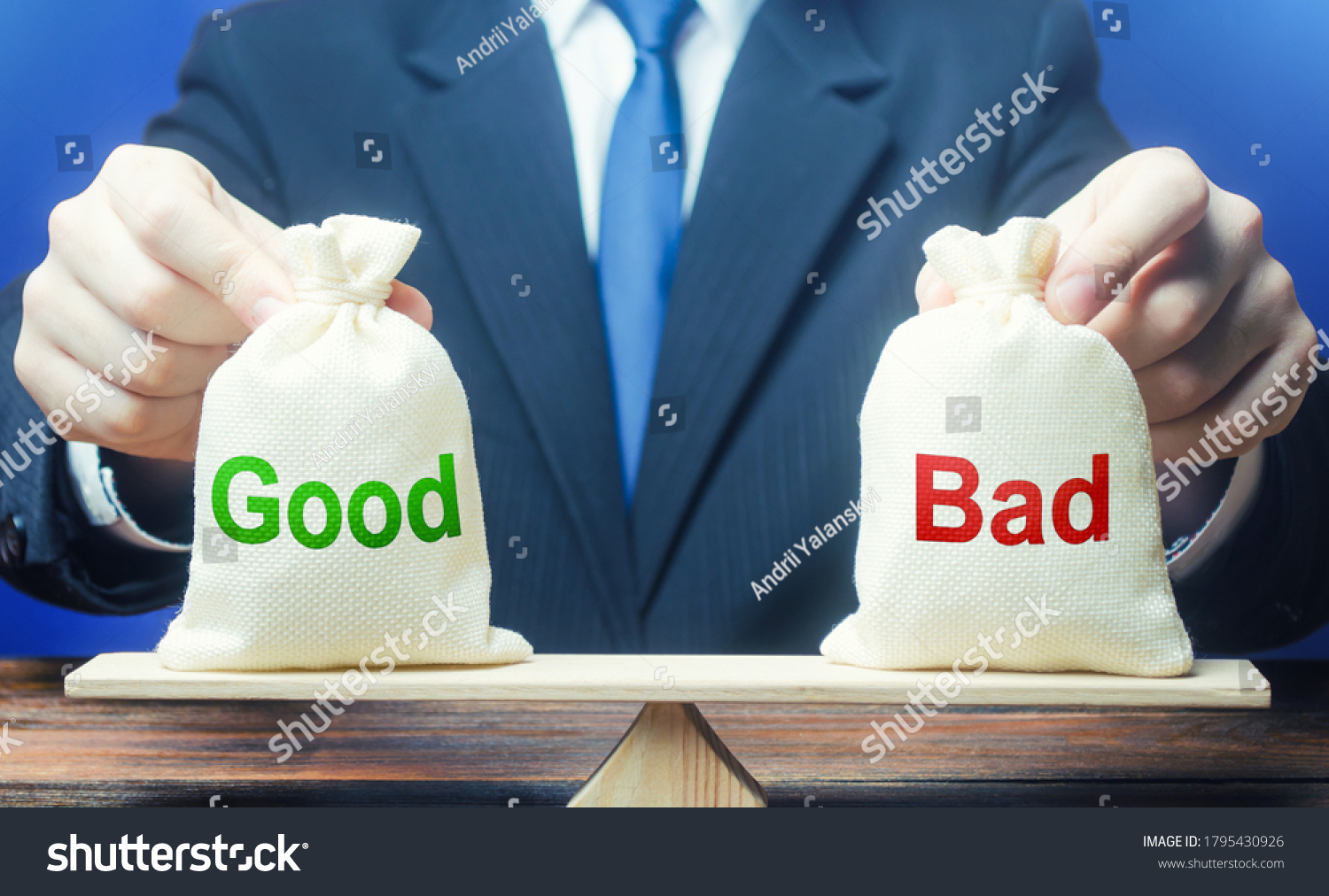 Businessman holds good and bad bags on scales. Evaluating the actions of other people, weighing the positive and negative qualities. Good and evil, karma. Introspection. Ethics and acceptability. #1795430926