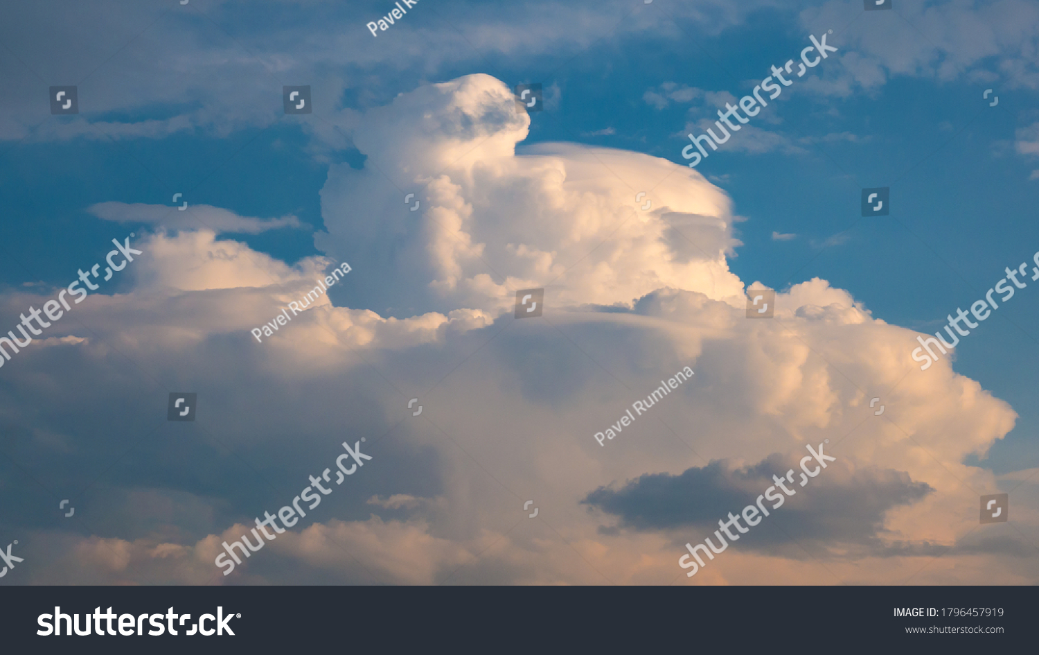 Massive rain cloud - cumulus congestus or towering cumulus - forming in the blue sky #1796457919