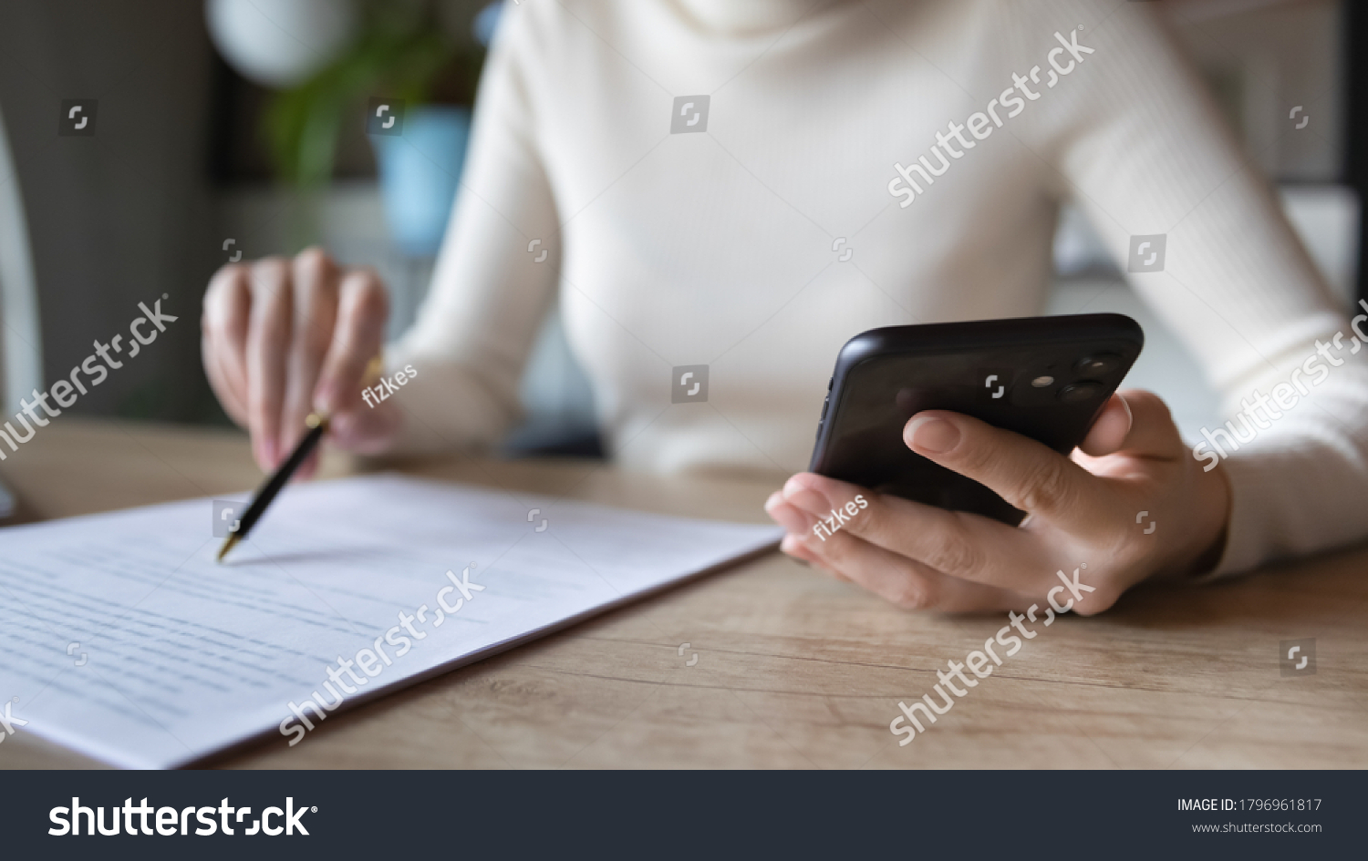 Close up focused financier reading paper contract agreement, checking latest investment news in smartphone application indoors, concentrated female editor reading document or report at workplace. #1796961817